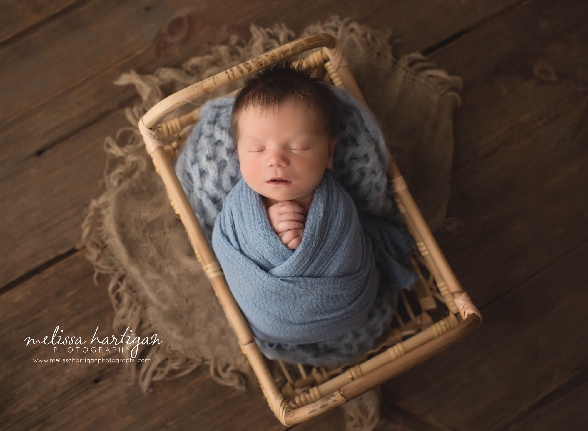 newborn baby boy wrapped in blue wrap posed in basket CT baby photographer