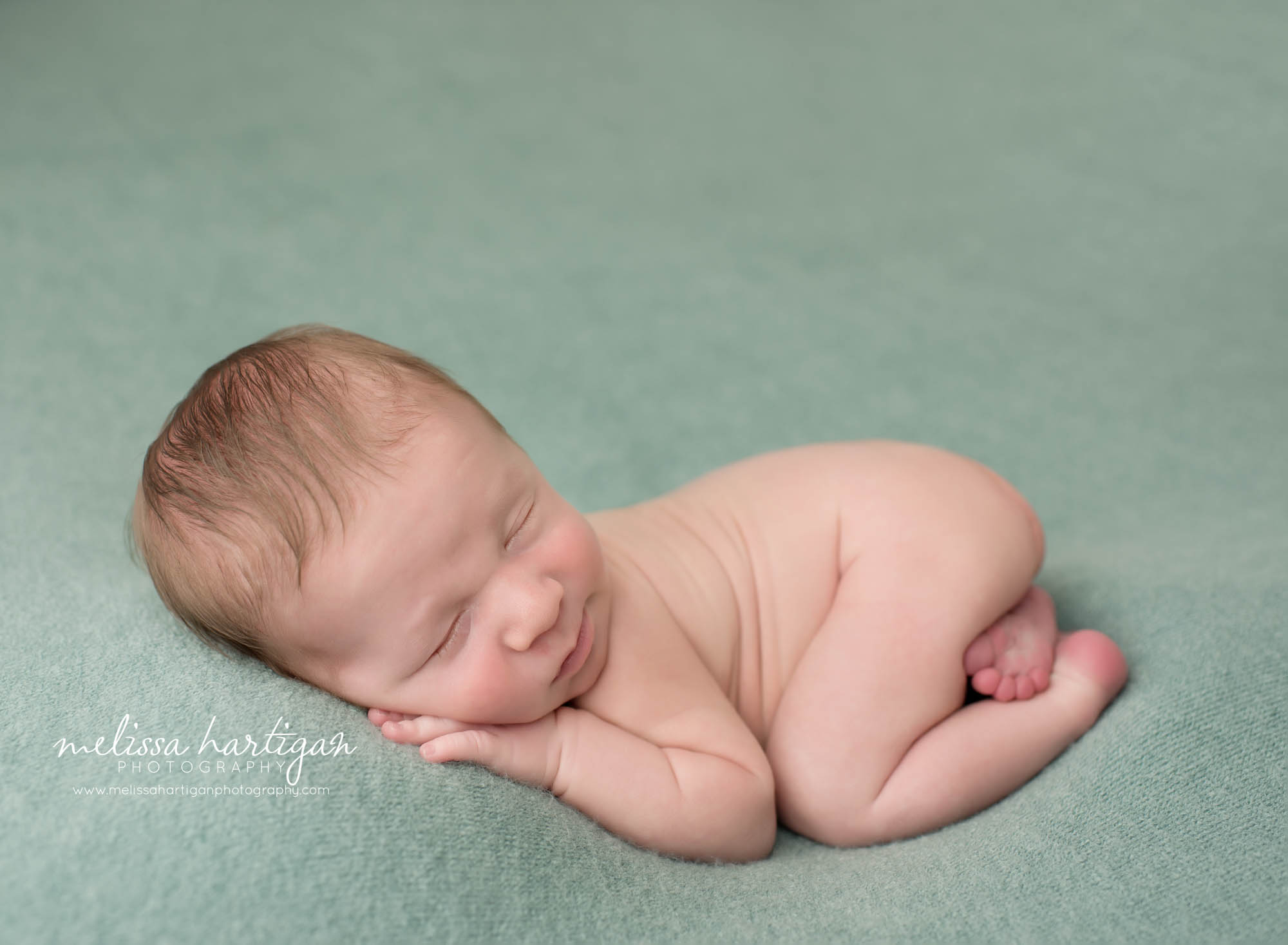 newborn baby boy posed on teal green backdrop with bum up Middlesex county newborn photography