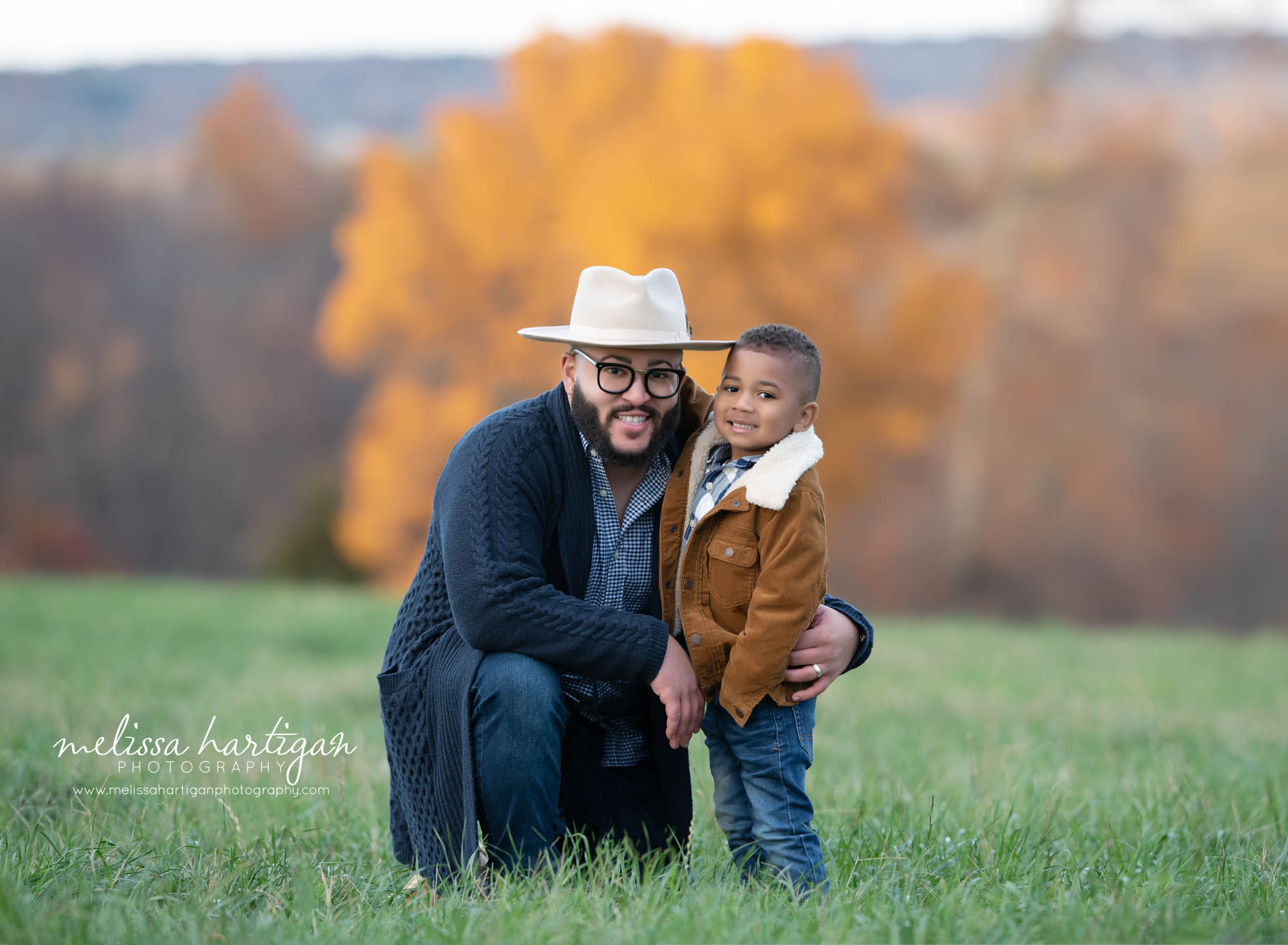 dad kneeling down with older son family photography session captured outside CT family photographer