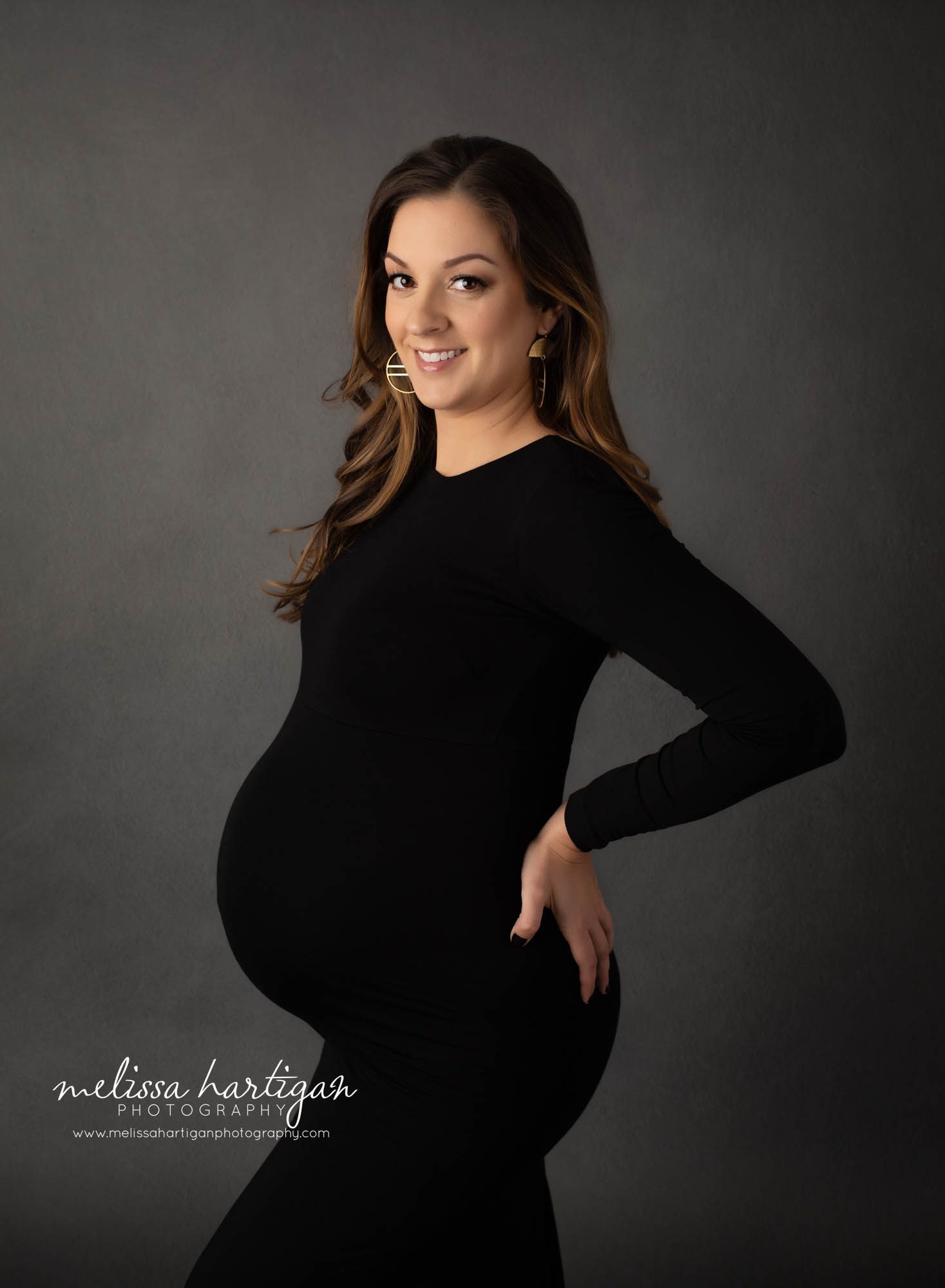 pregnant mom holding backside showcasing pregnant belly in maternity photography session