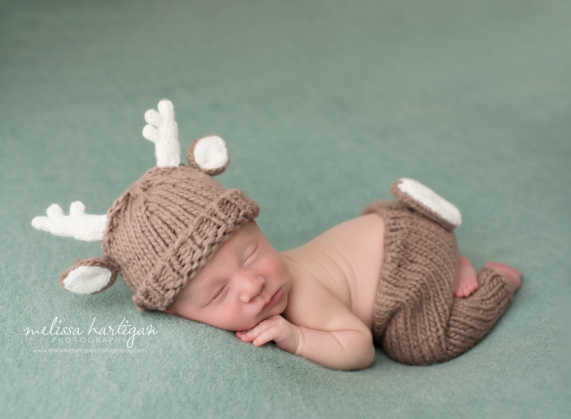 newborn baby boy posed in reindeer newborn prop pants and hat set CT newborn photography