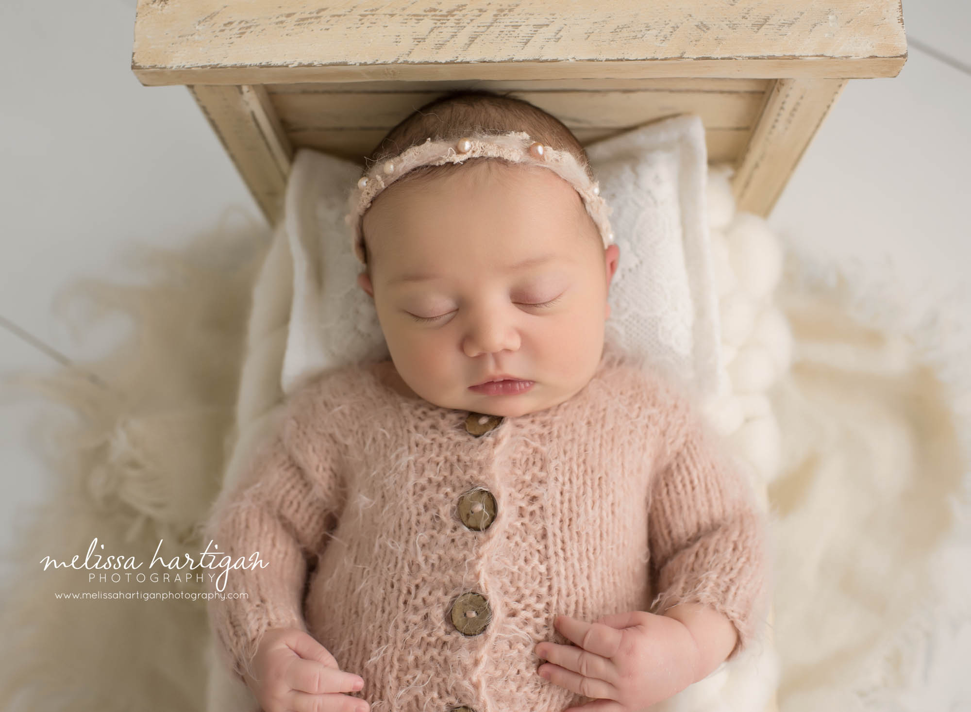 newborn baby girl posed on back on newborn bed prop New london County baby photography