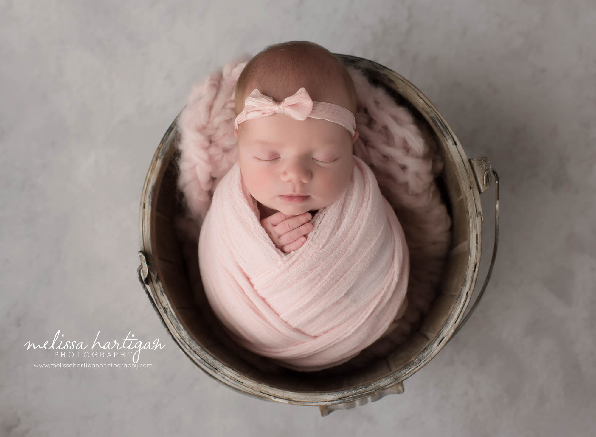 newborn baby girl wrapped in pink wrap wearing bowl headband ct newborn photography tolland county