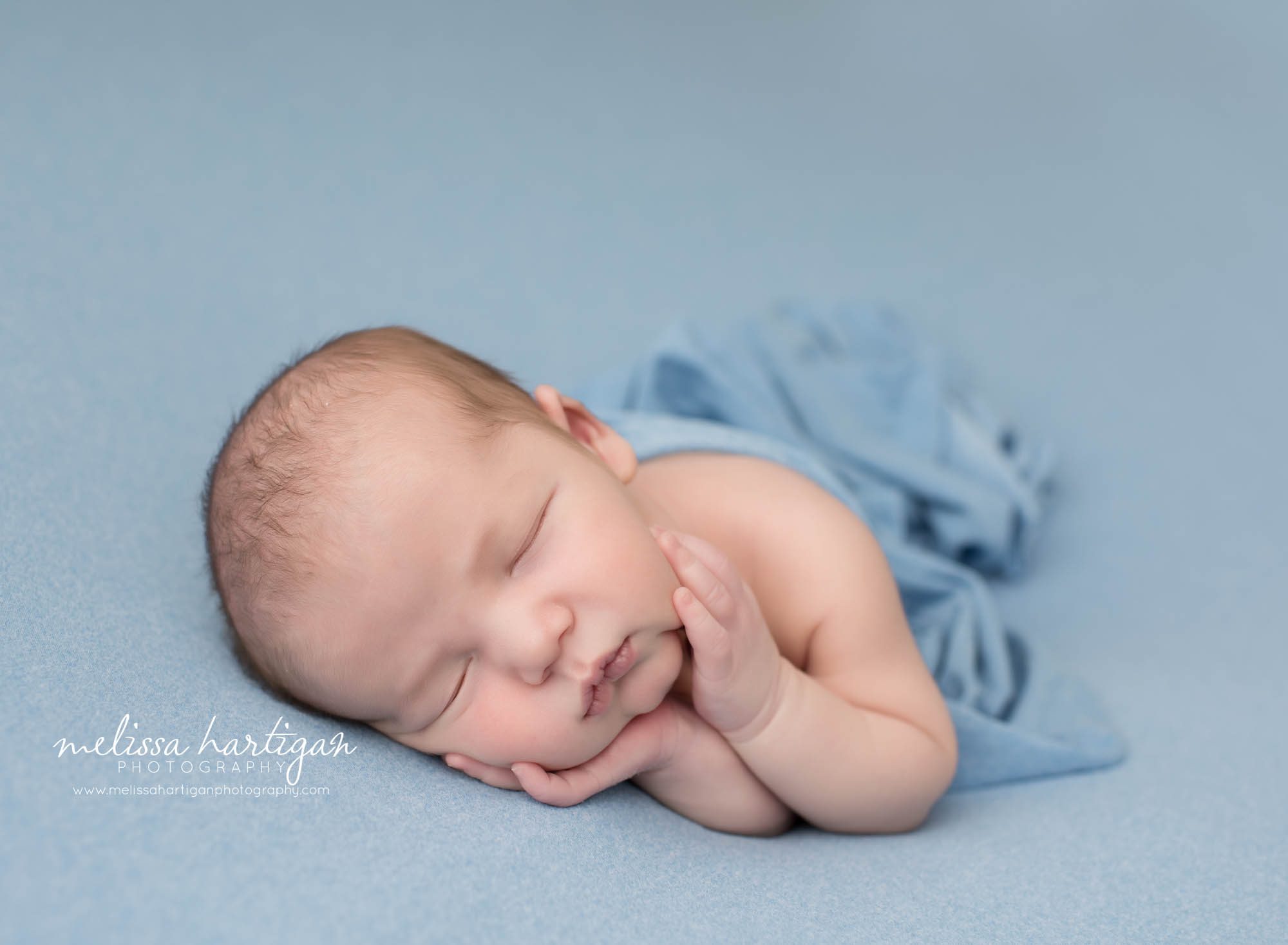 newborn baby boy posed on blue backdrop in timber pose newborn photography CT