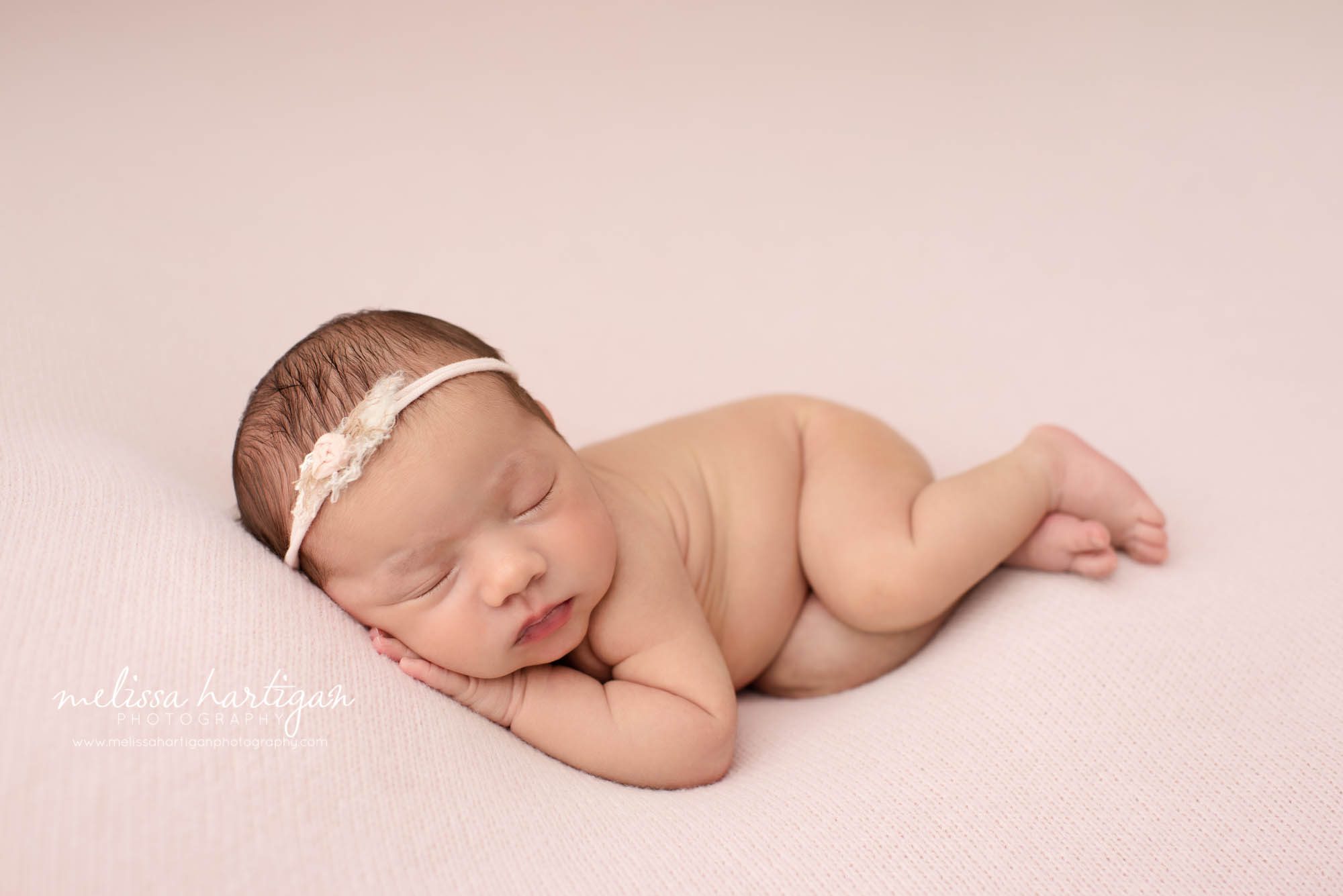 newborn baby girl posed on side wearing headband tieback east hartford baby photography