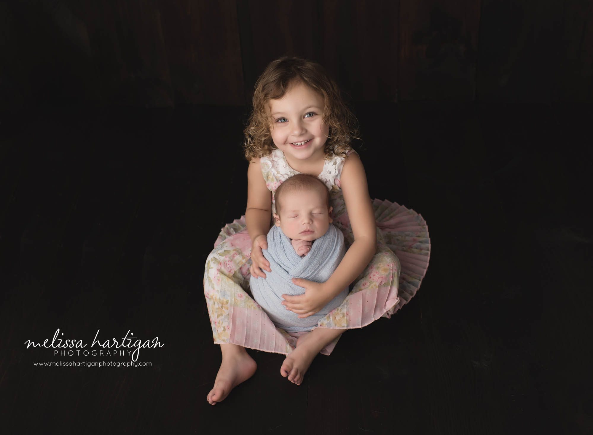 newborn baby boy wrapped in light blue wrap with older sister holding him for sibling pose newborn photographer CT