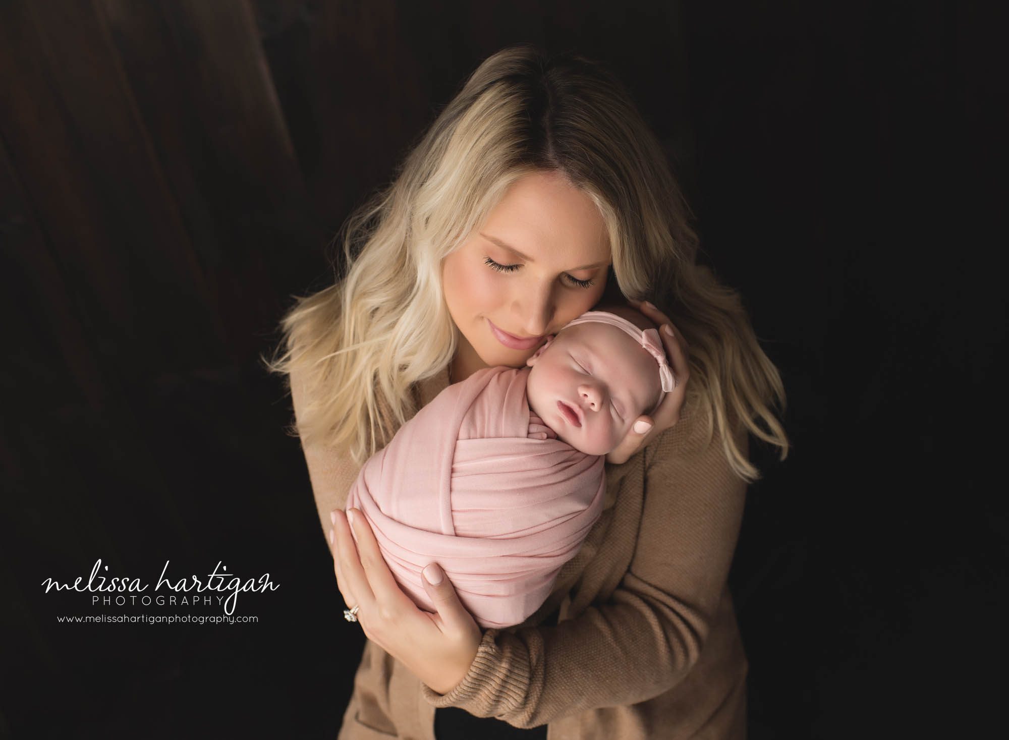mom holding newborn baby girl wrapped in pink tolland county ct newborn photographers