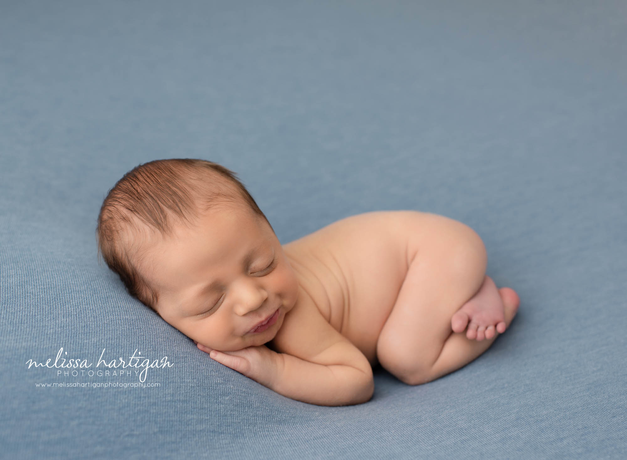 newborn baby boy posed on blue backdrop CT newborn photographer