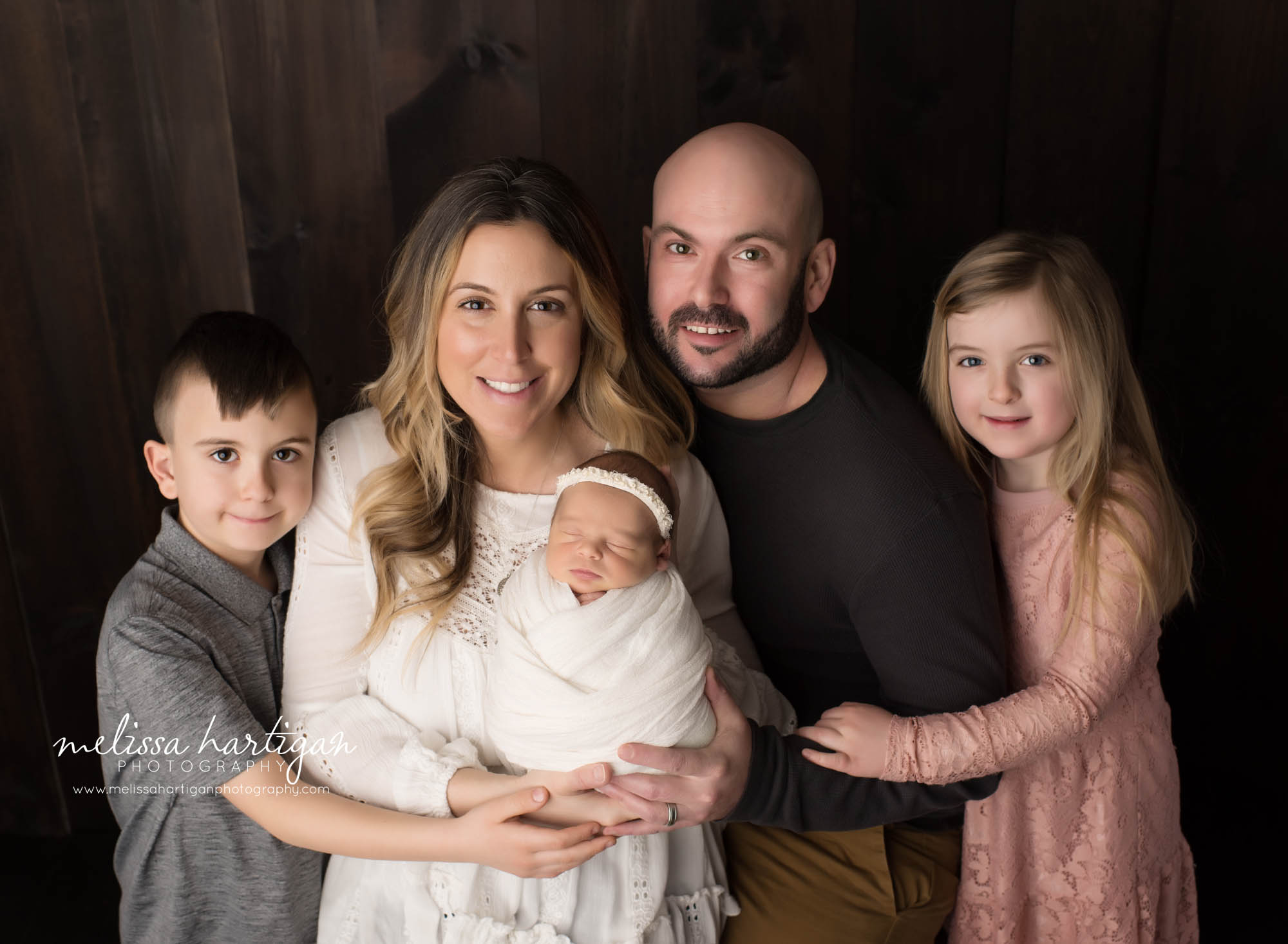 family pose with mom dad big brother big sister baby girl wrapped in ivory cream wrap CT newborn Photography