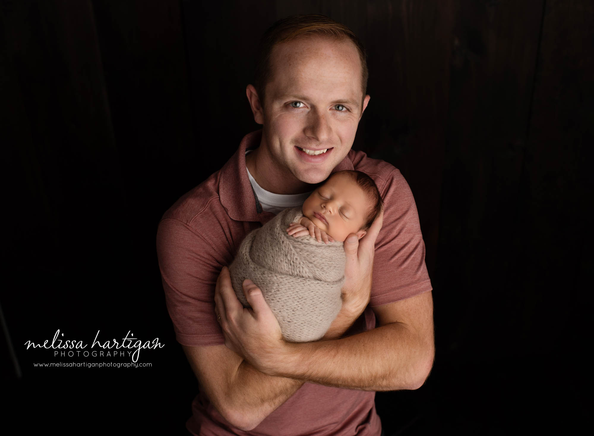 dad holding newborn son in family pose