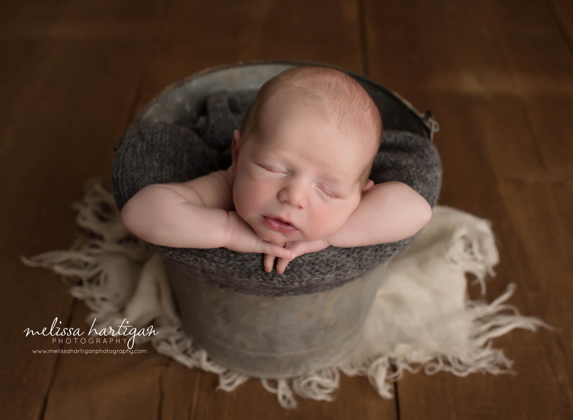newborn baby boy posed in bucket with gray knitted wrap CT newborn Photography