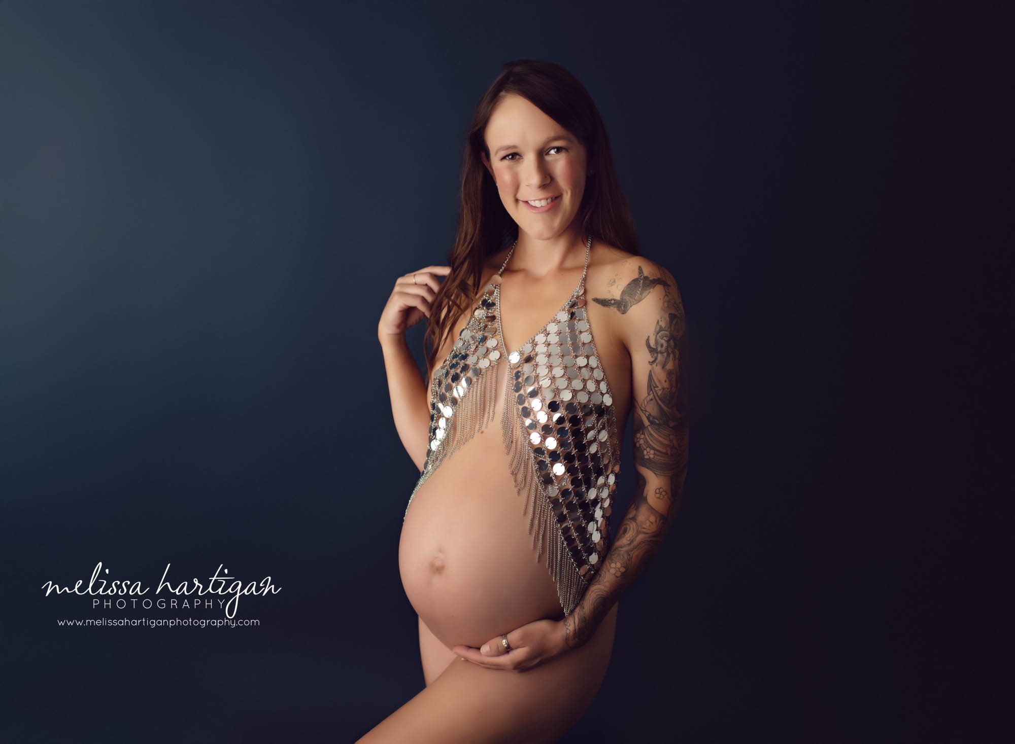 pregnant mom standing maternity pose wearing sequinned top