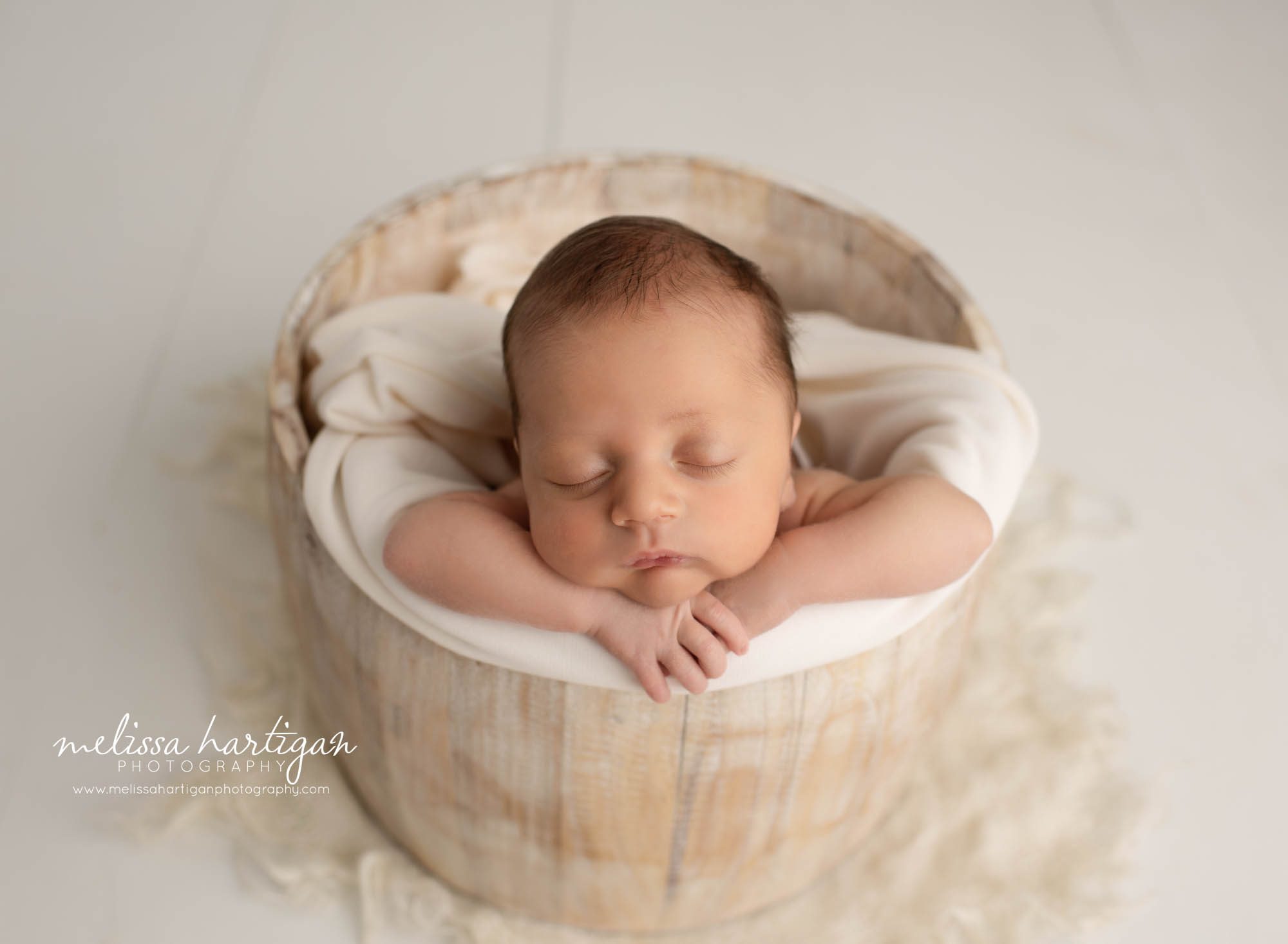 newborn baby boy posed in wooden barrel with cream wrap newborn photography CT
