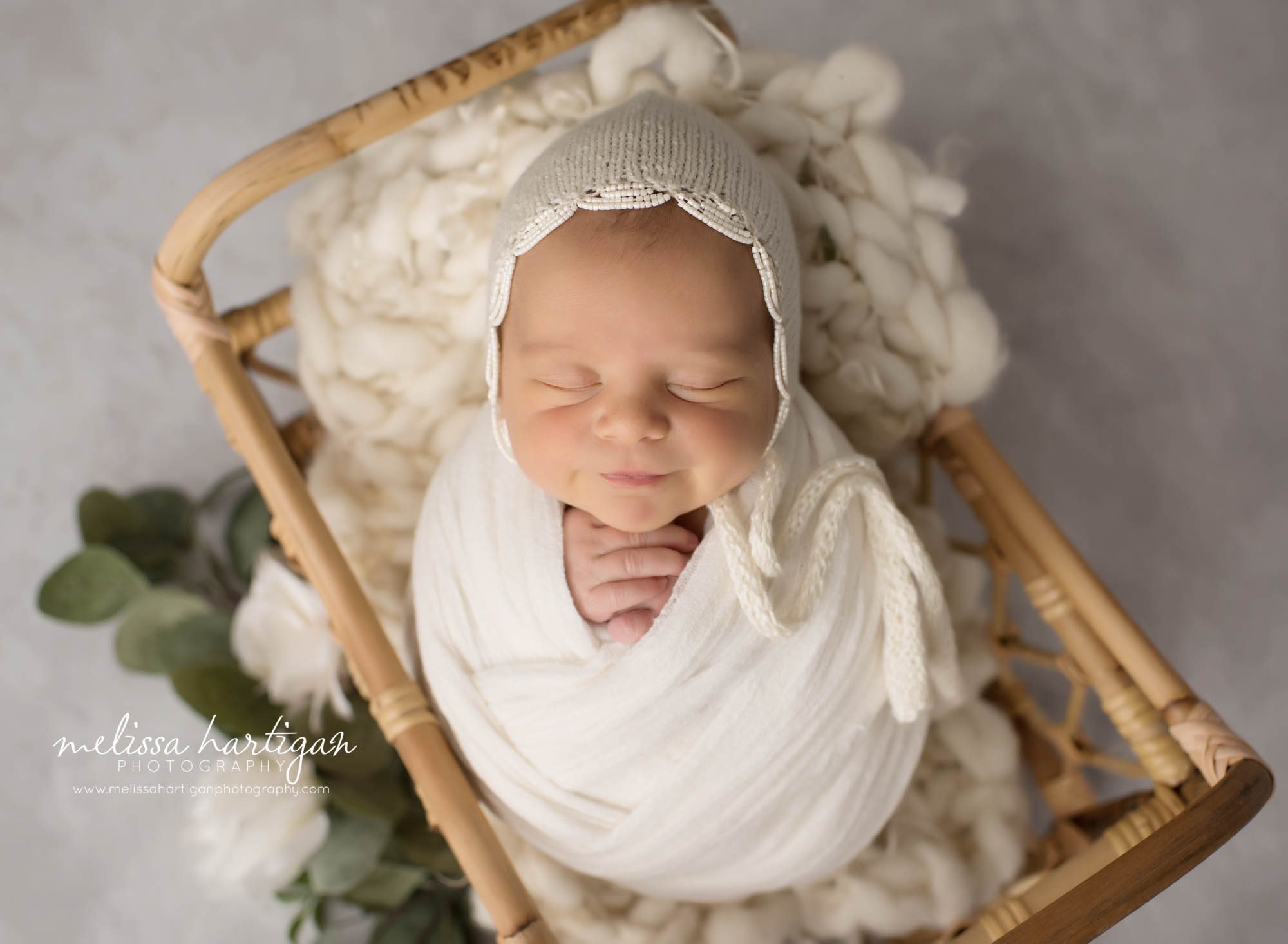 newborn baby girl wrapped in ivory wrap wearing knitted bonnet with beads newborn photography windsor CT