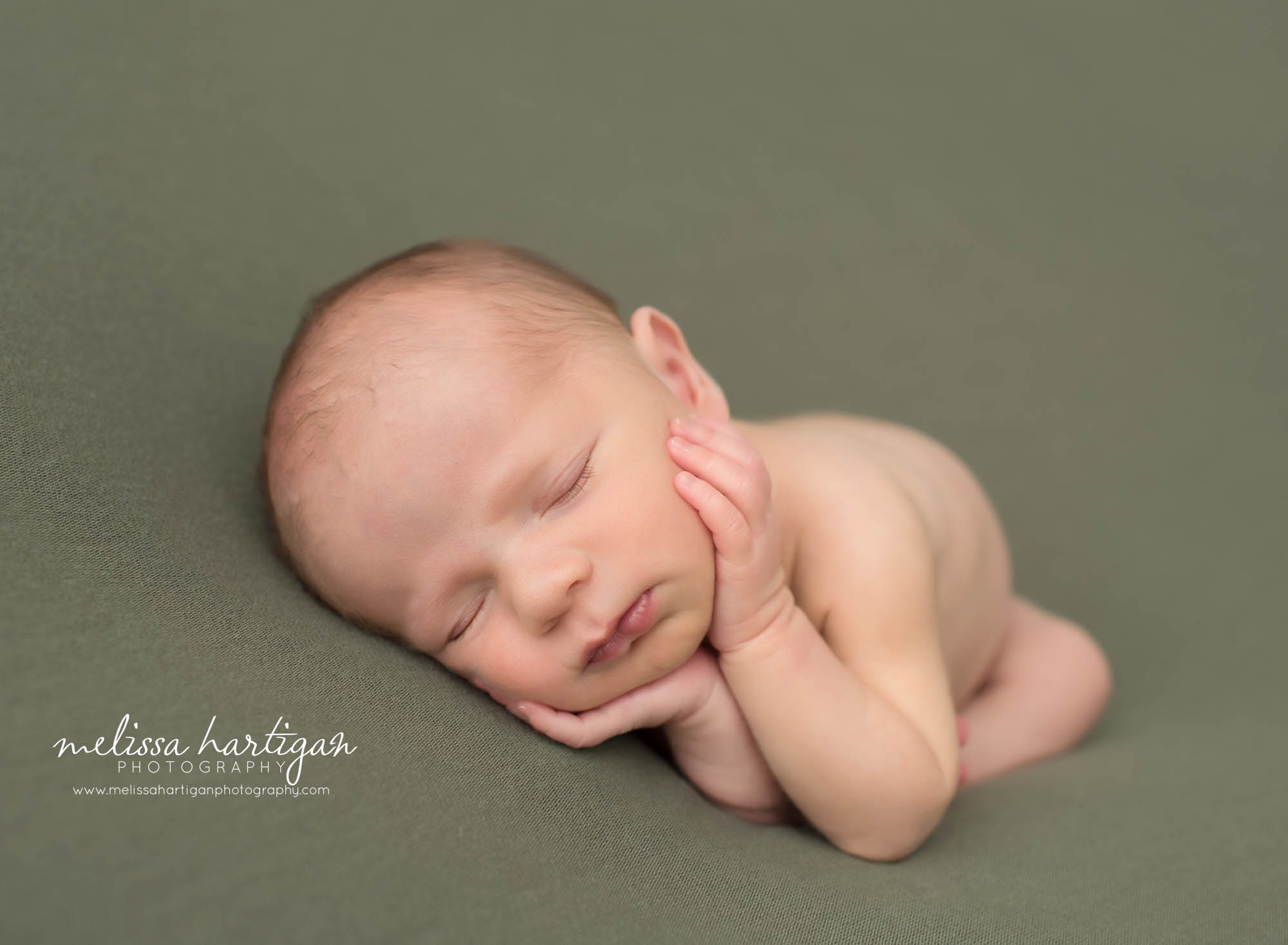 newborn baby boy posed on green backdrop sleeping newborn photography CT