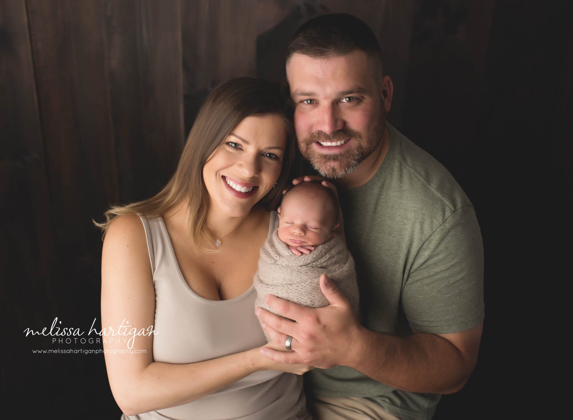 newborn baby boy posed with mom and dad family photo