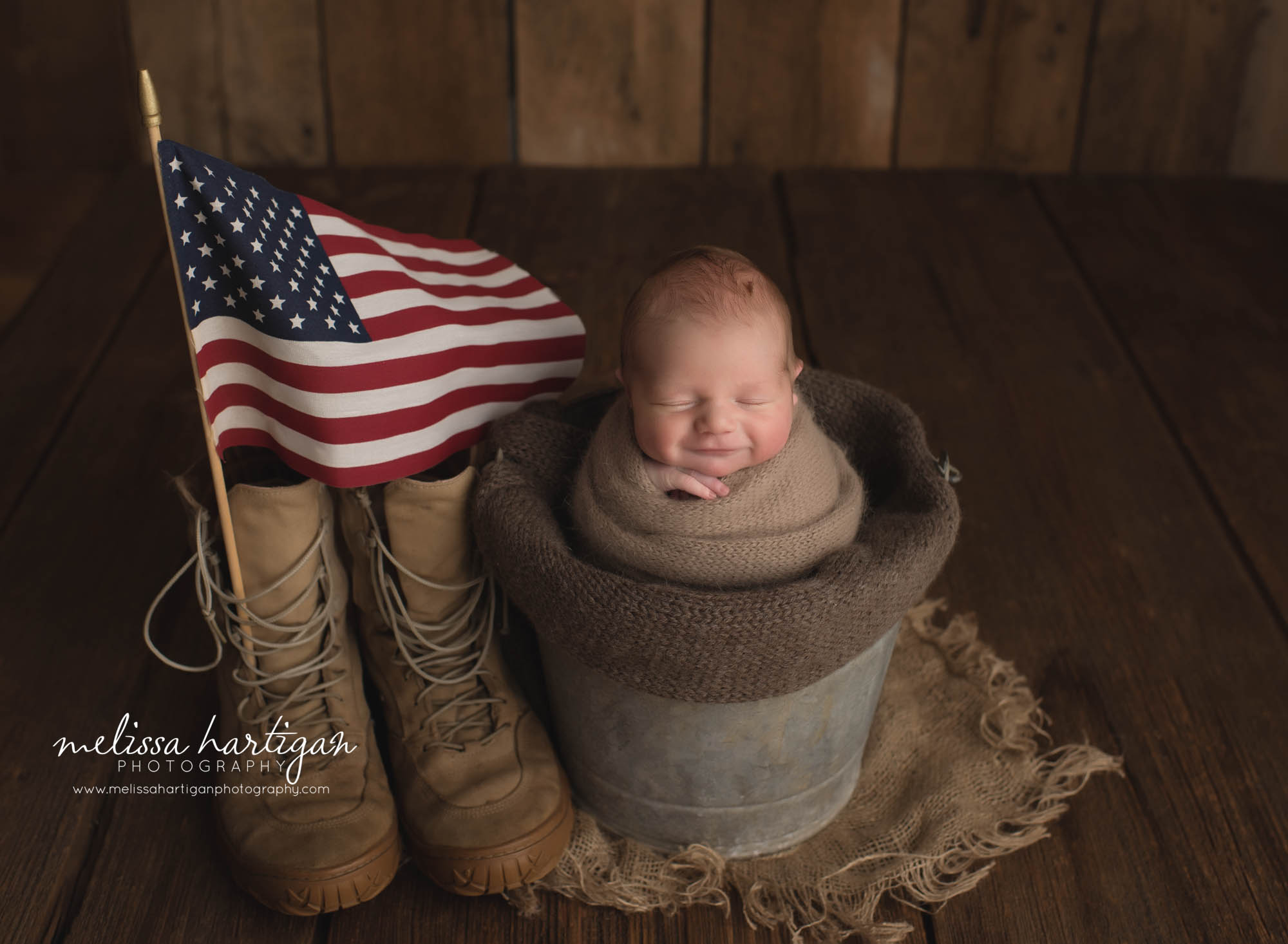 newborn baby boy posed in bucket with american flag