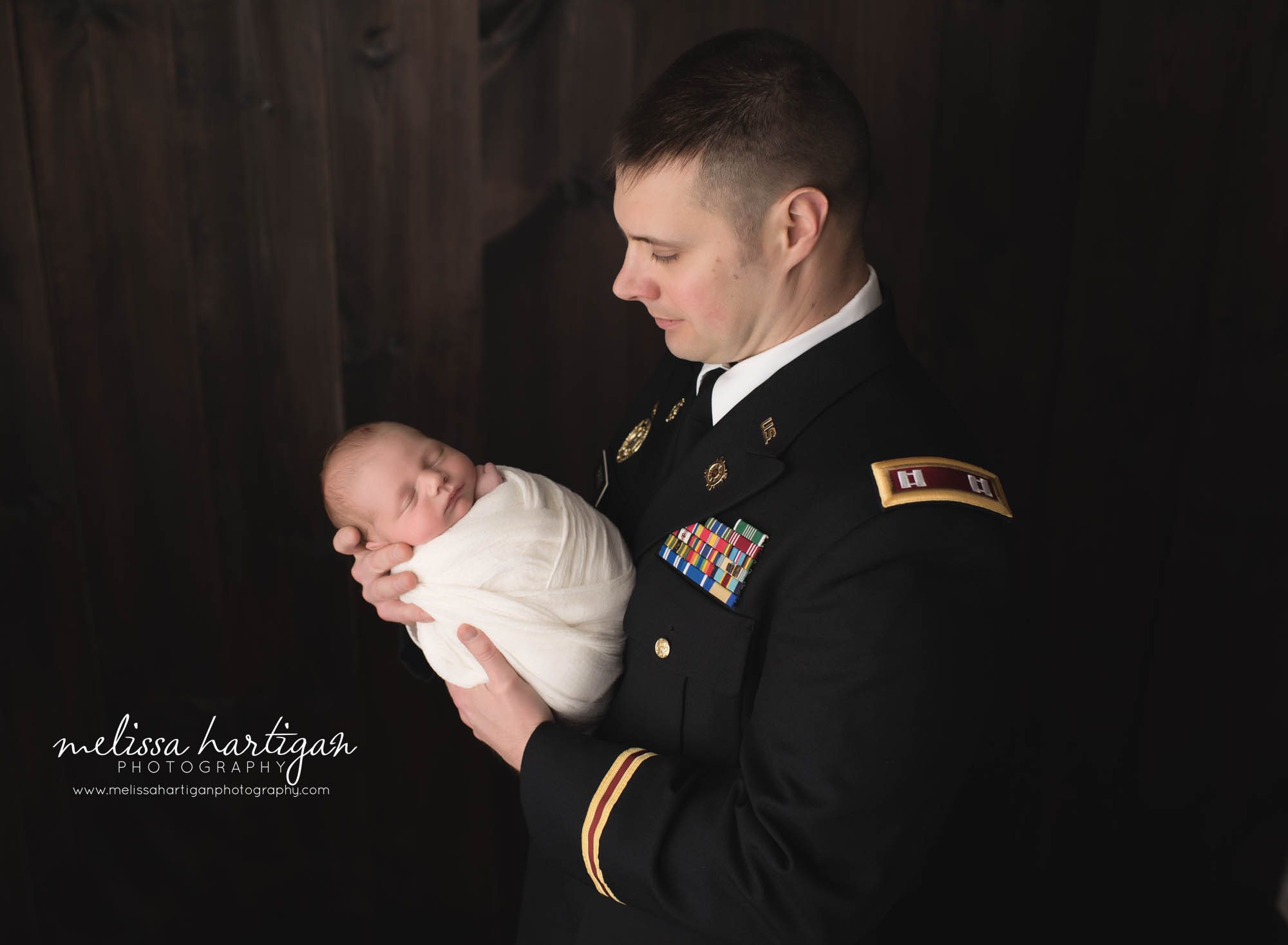 dad holding son in studio newborn photography family parent pose