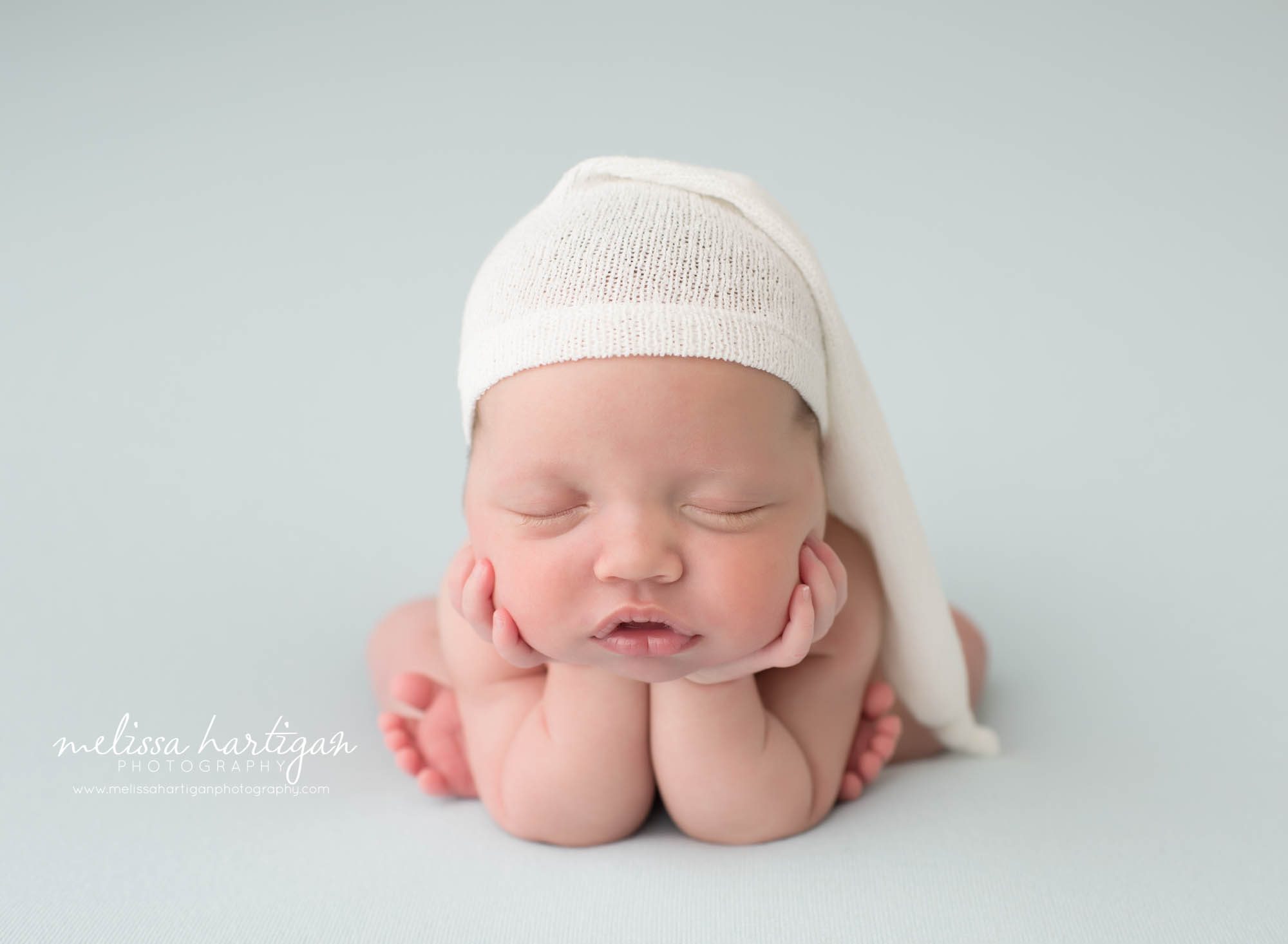 newborn baby boy posed froggy pose wearing cream sleepy cap newborn photographer tolland county CT