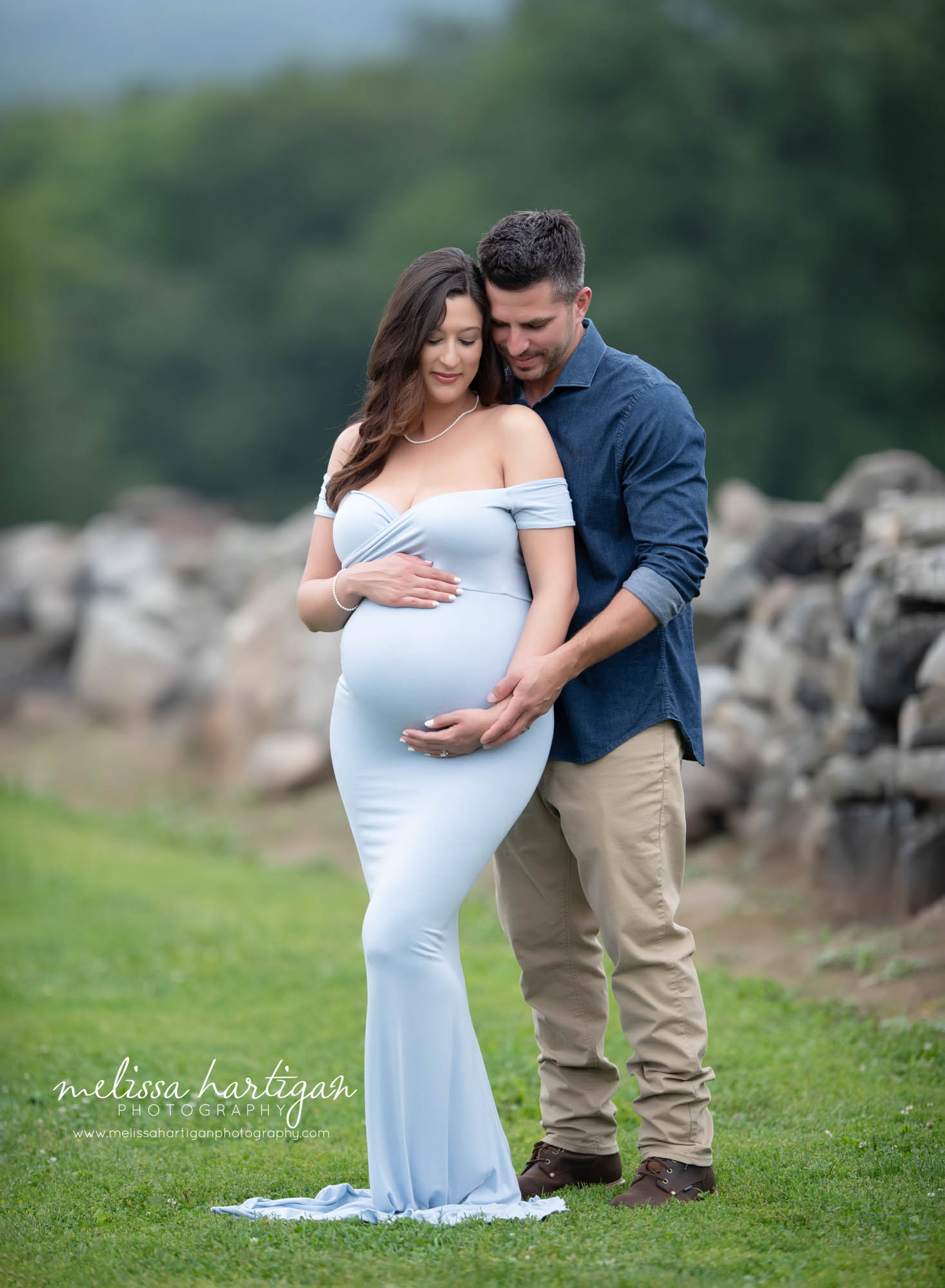 pregnant mom to be and dad to be holding baby bump maternity photography couples pose outside CT park