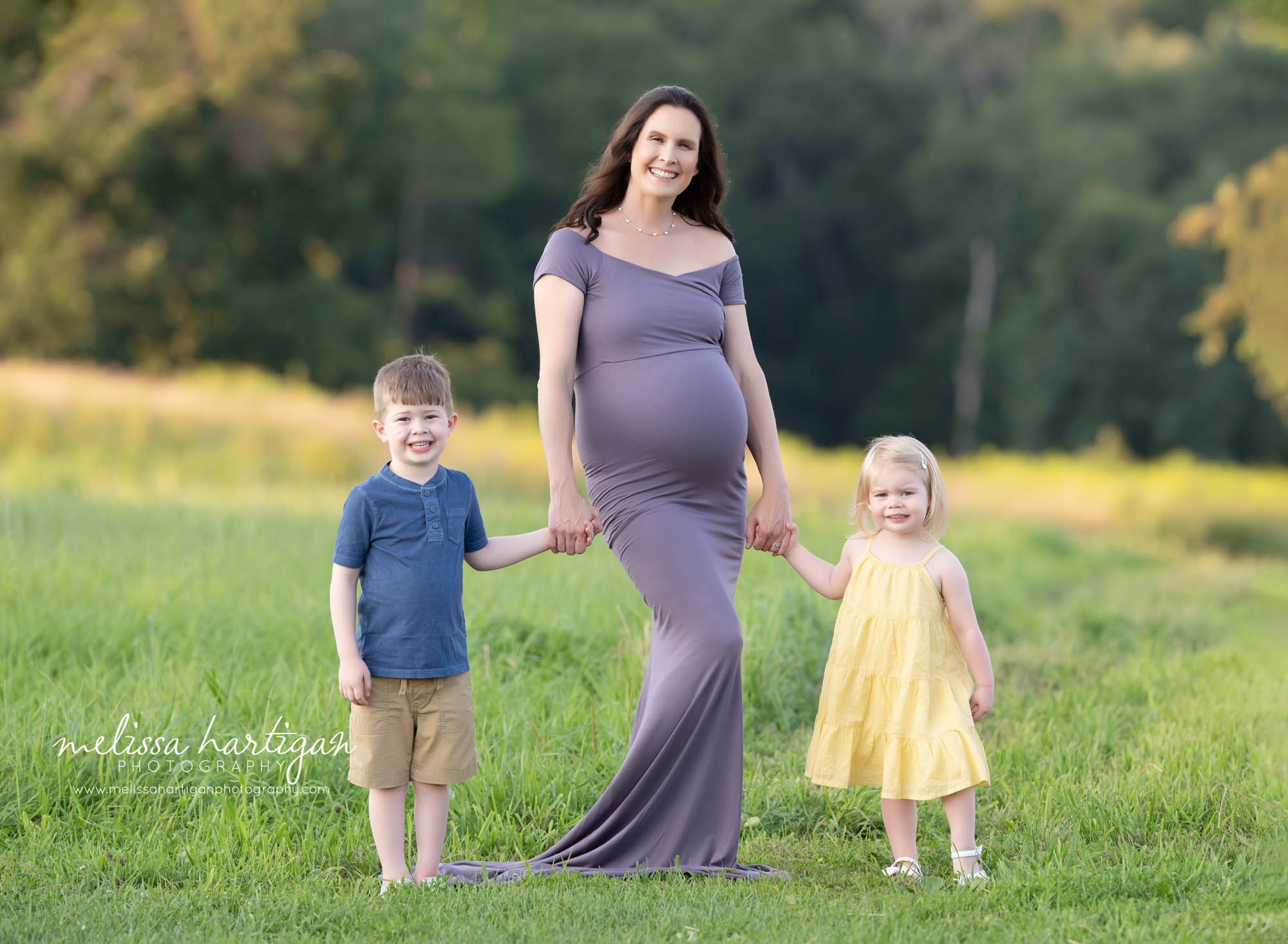 mom holding son and daughters hands family style maternity picture