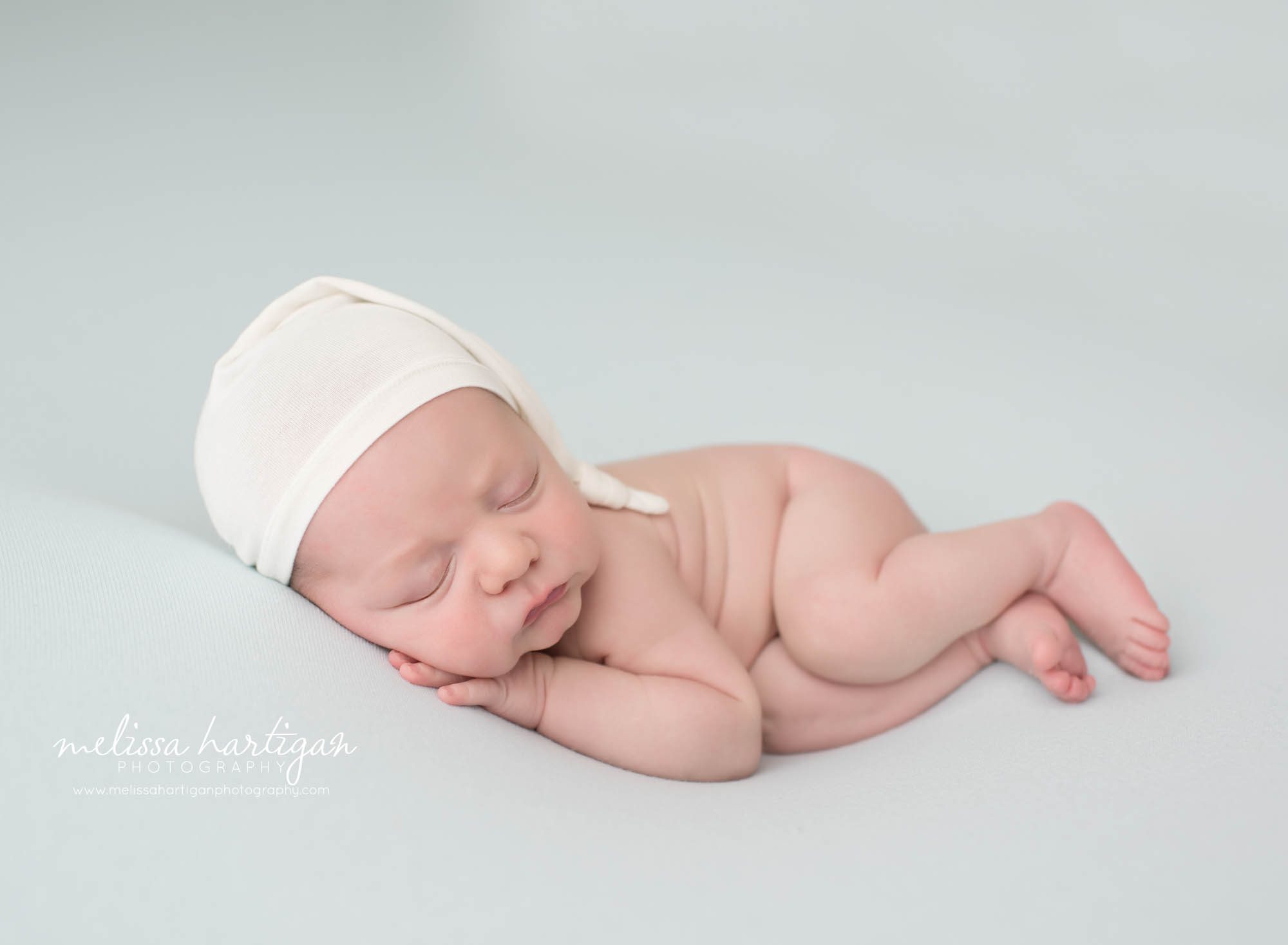 newbporn baby boy posed on side with cream sleepy cap newborn photography east windsor