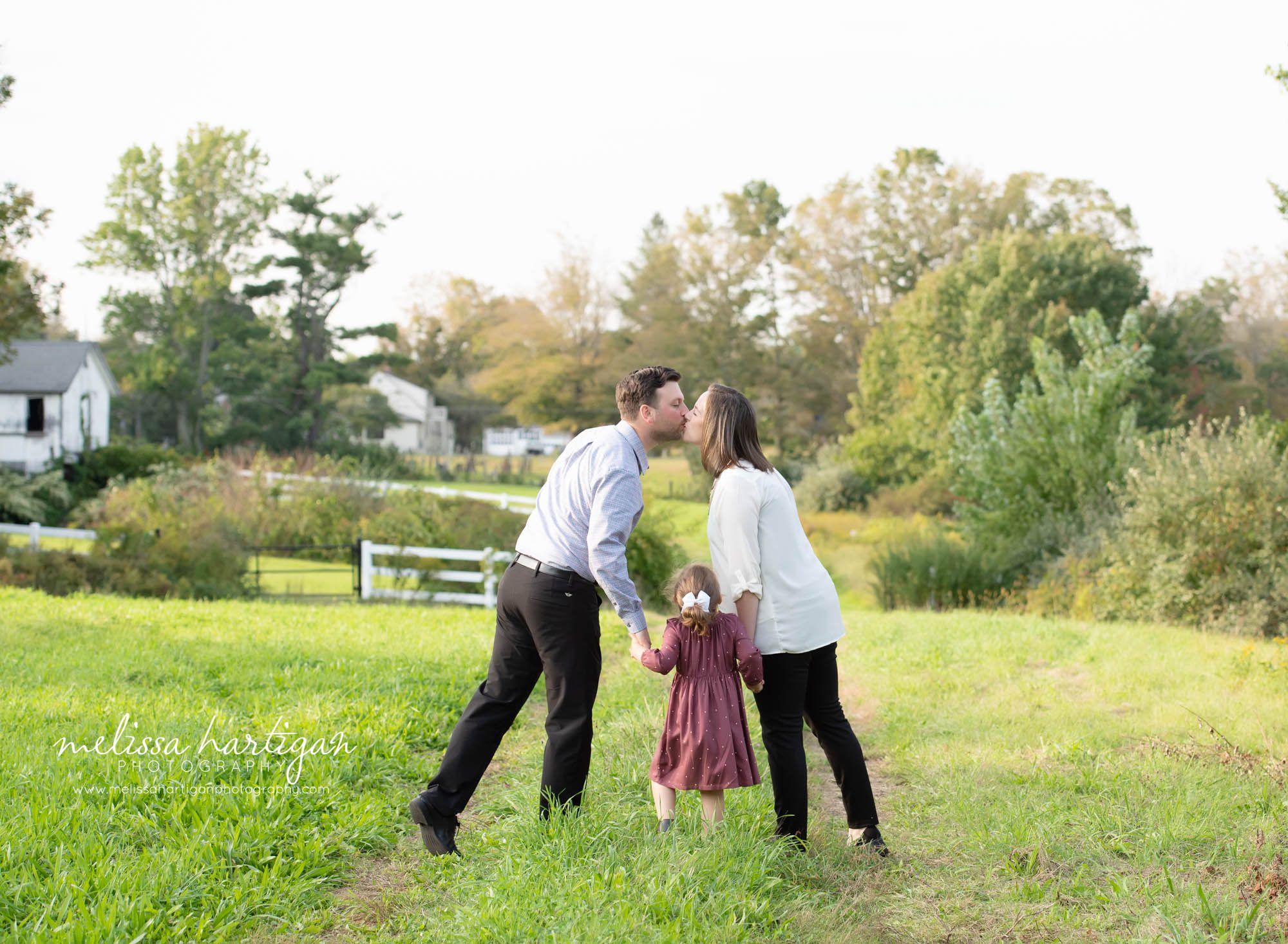 mom dad kissing daughter looking up family photography ledyard ct