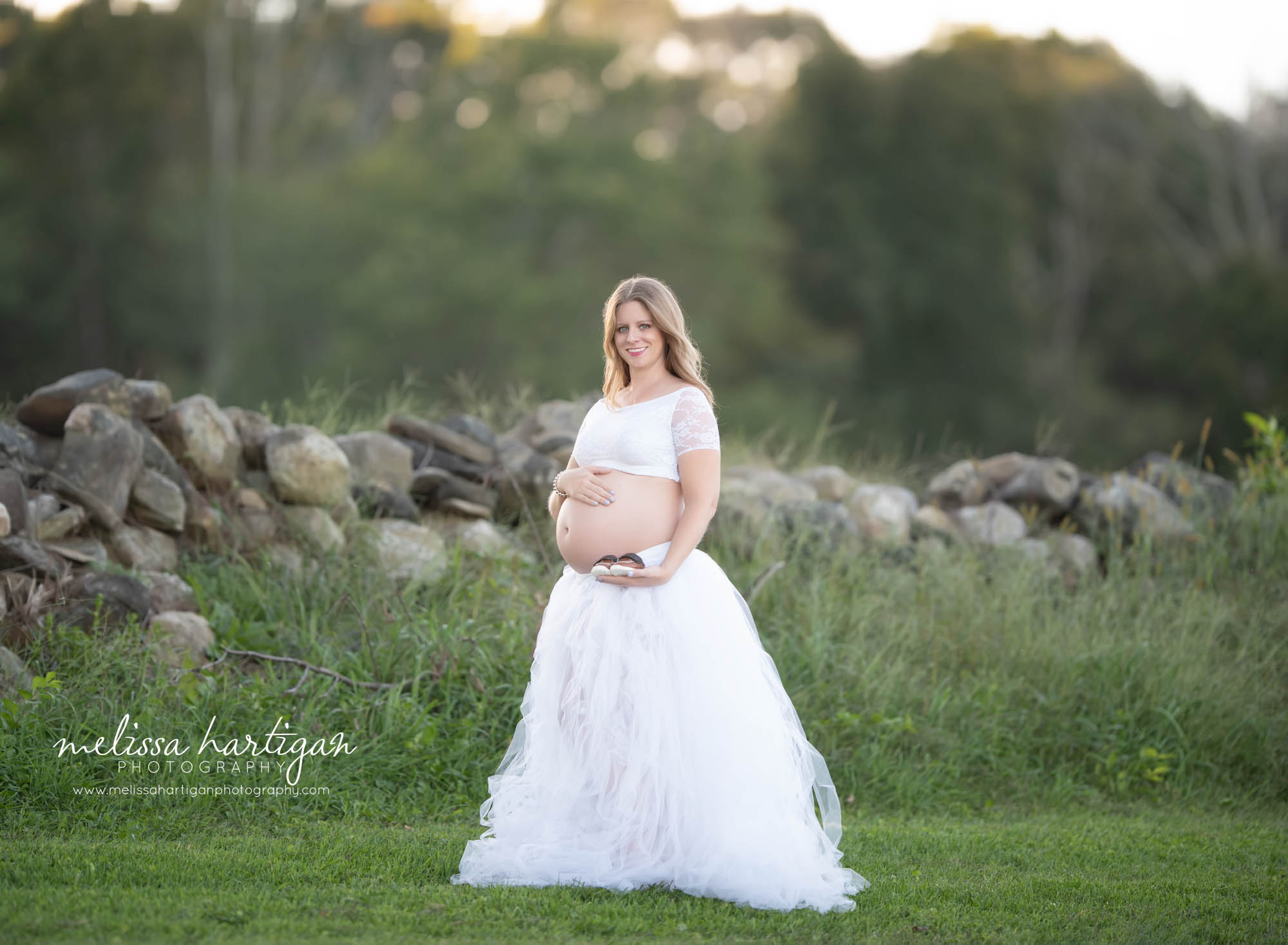 mom wearing white 2 piece maternity top and skirt