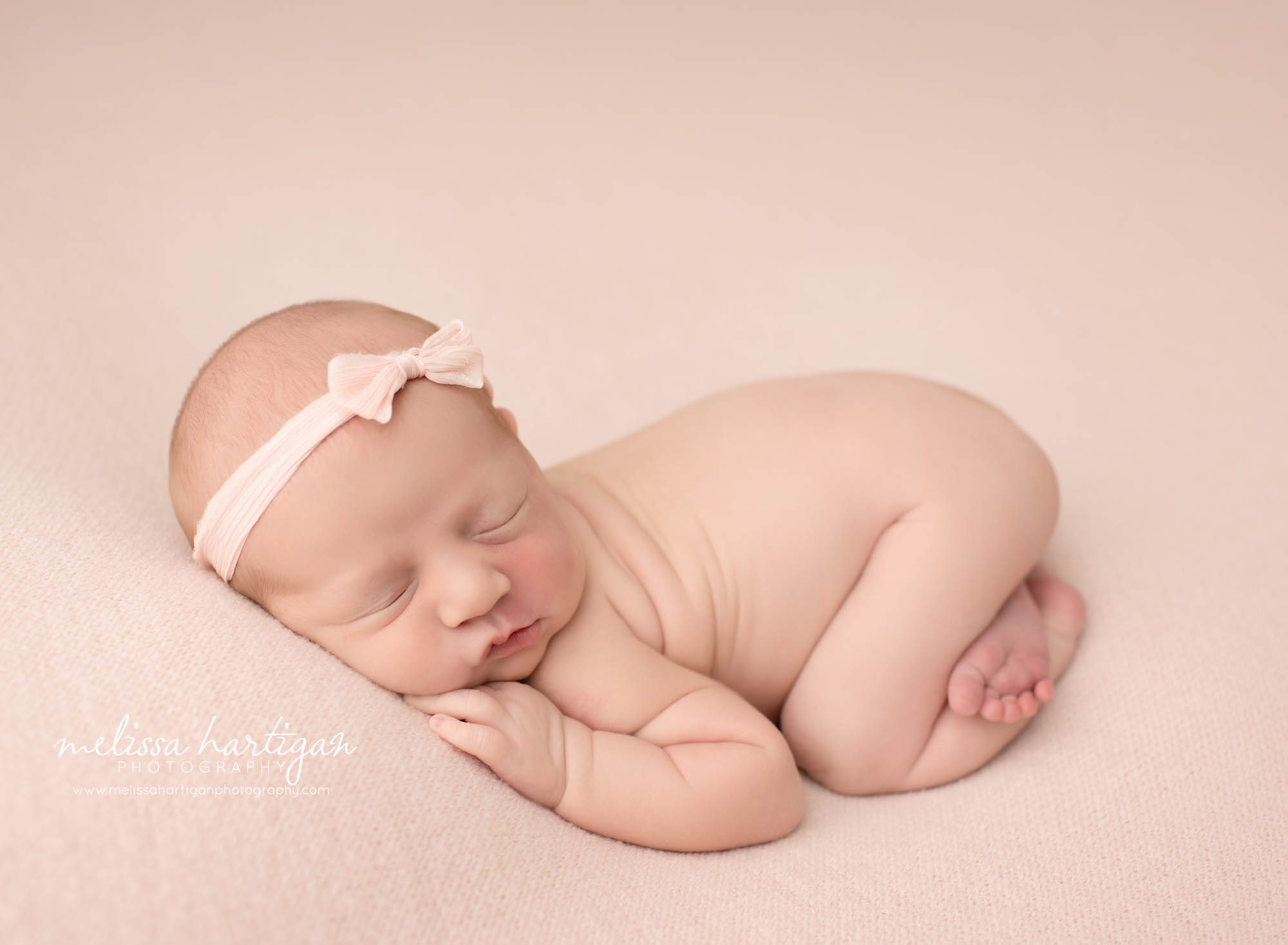 newborn baby girl posed on tummy bum up ppse wearing [ink bow headband baby photography CT