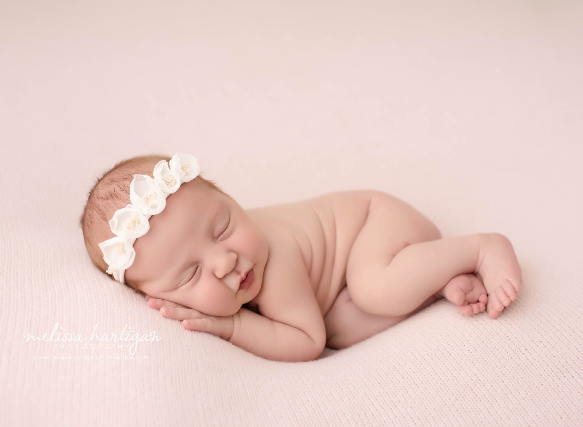 newborn baby girl posed on side wearing headband connecticut newborn photographer