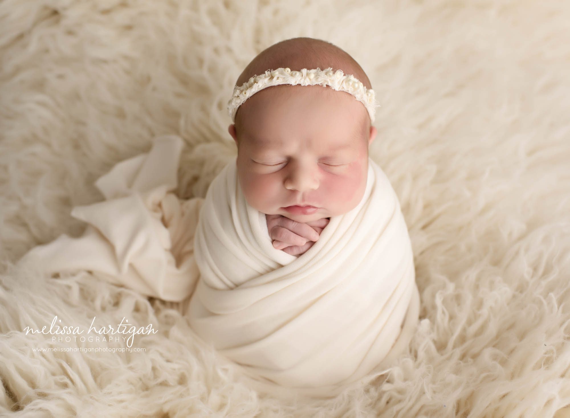 newborn baby girl wrapped in cream posed on cream flokati rug CT newborn Photography