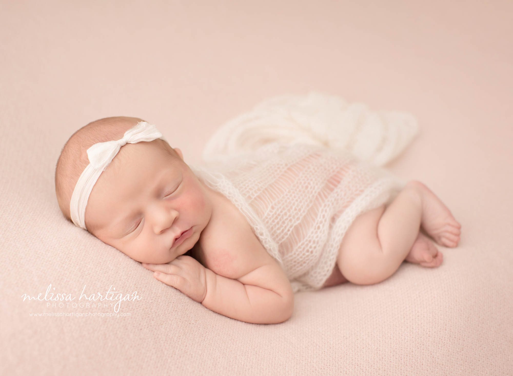 newborn baby girl posed on side with bow headband newborn photographer CT