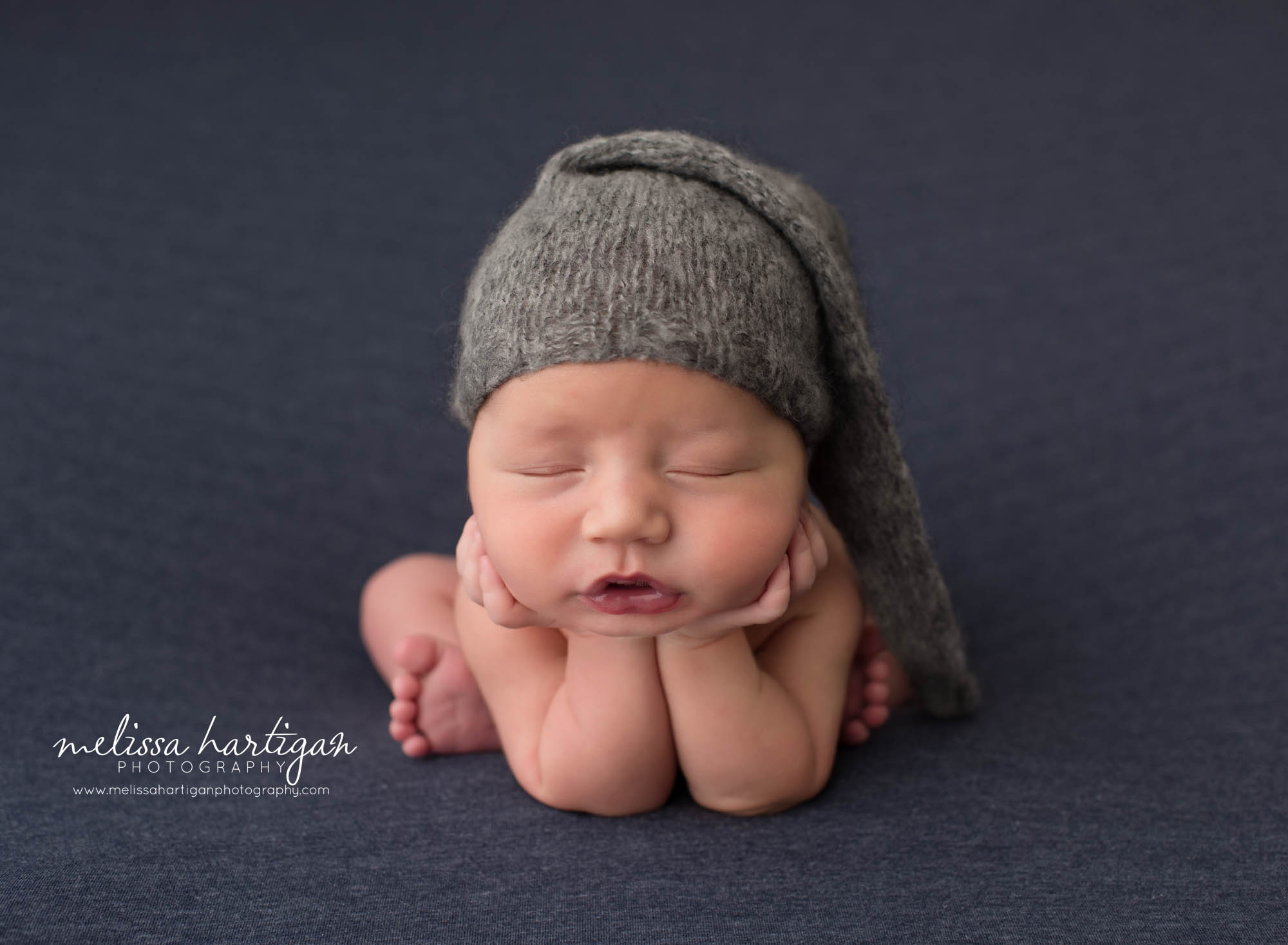 newborn baby boy posed froggy pose wearing sleepy cap newborn photography suffield CT