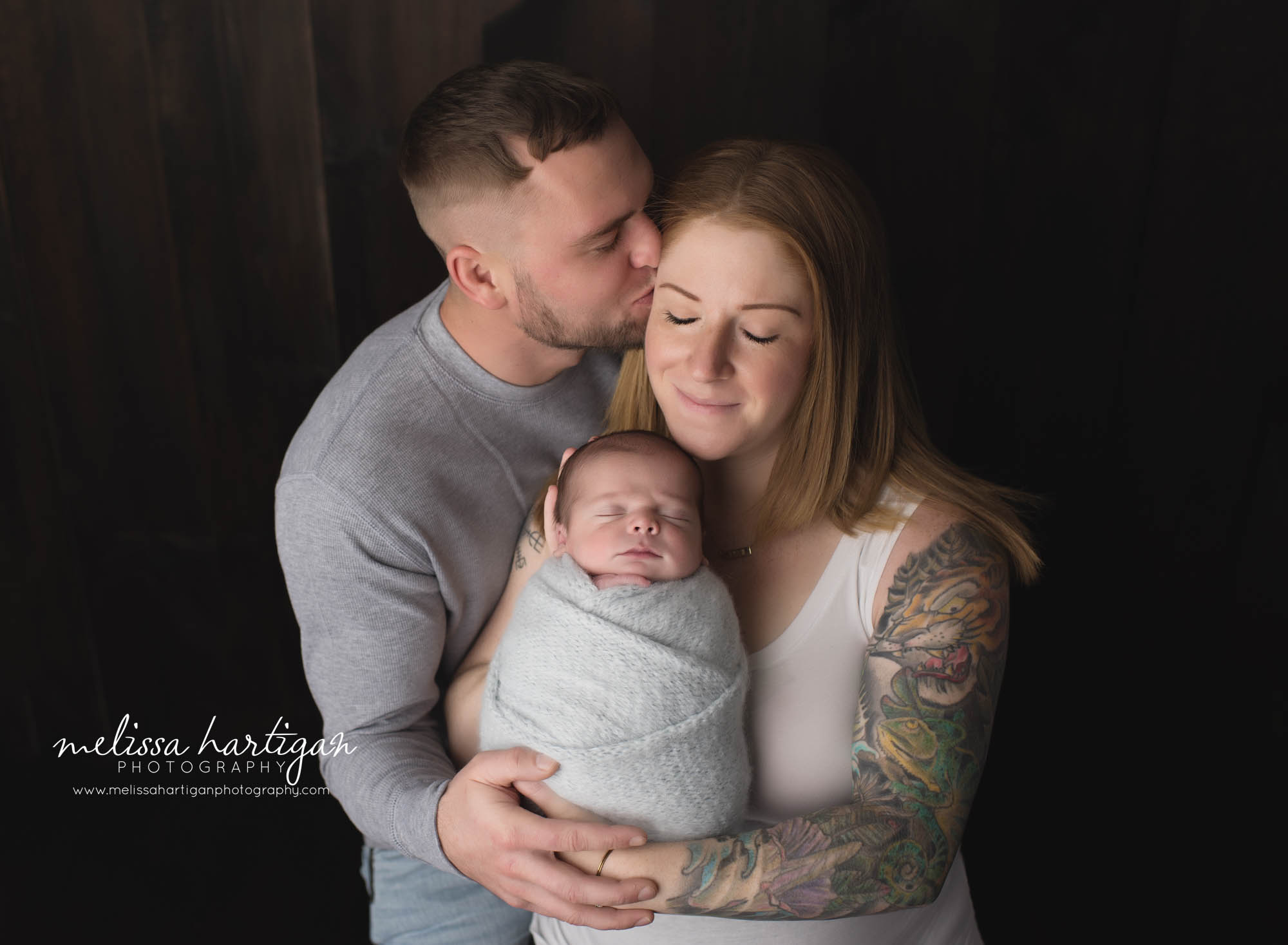 newborn baby boy wrapped in blue wrap posed with mom and dad parents pose newborn photography middlesex county CT