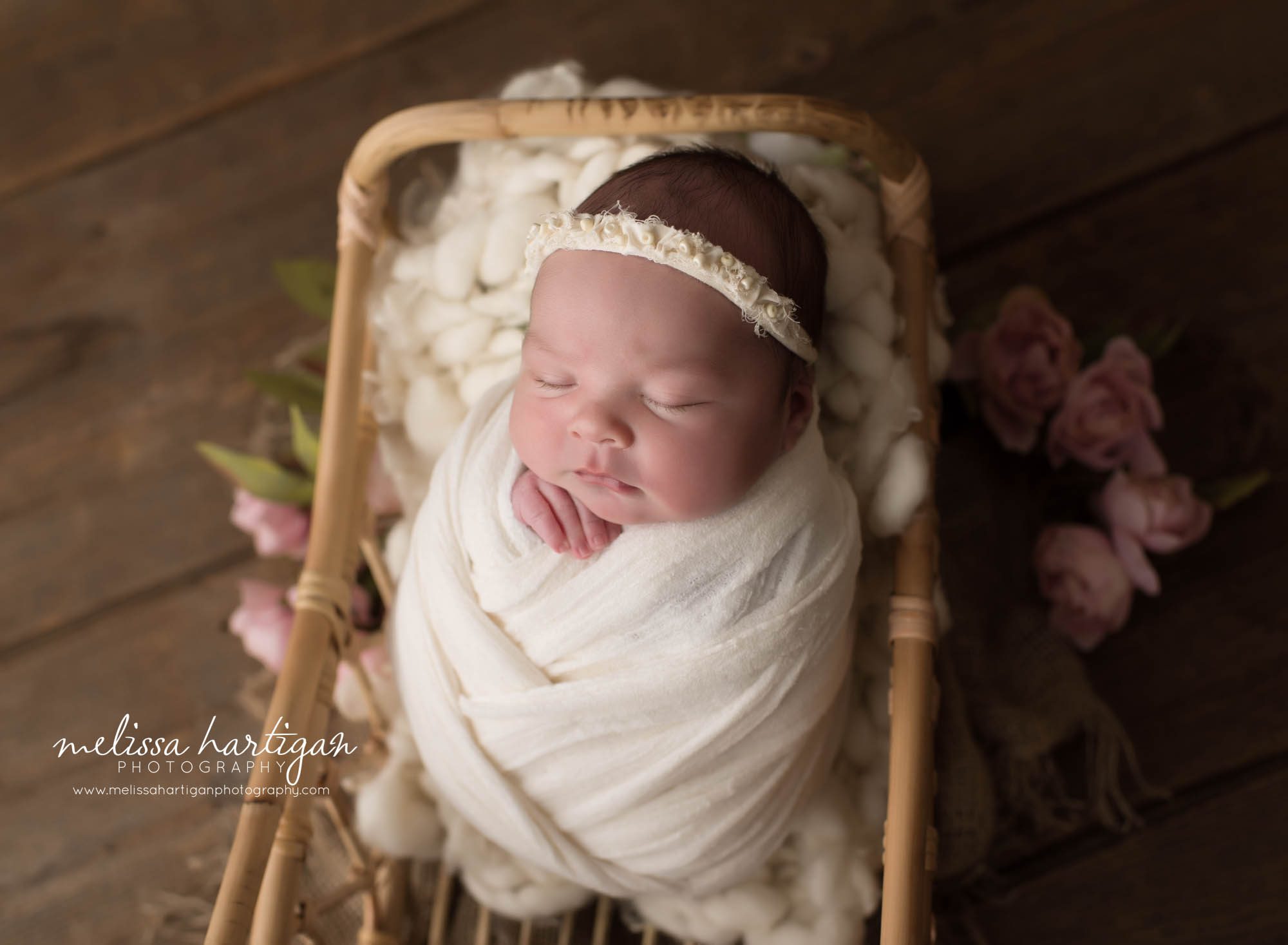 newborn baby girl wrapped in cream wrap posed in basket