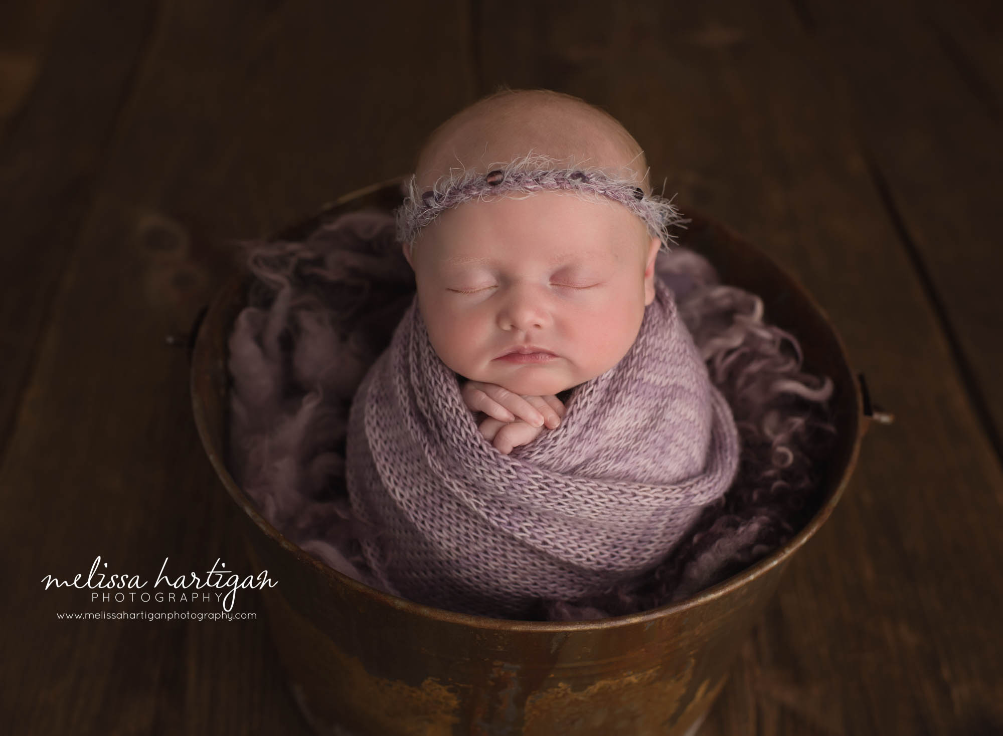 newborn baby girl wrapped in purple wrap posed in bucket CT baby photographer
