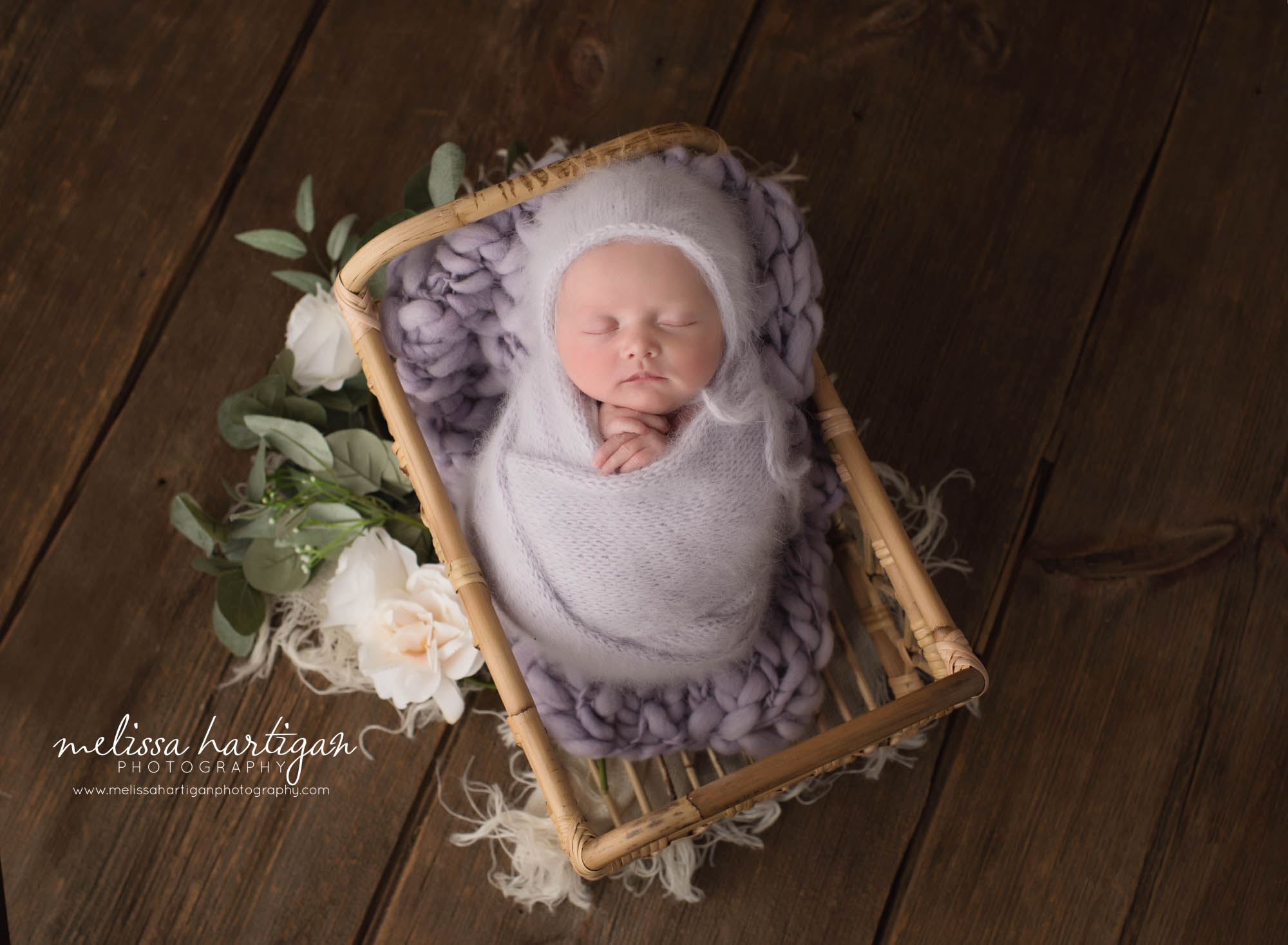 newborn baby girl wrapped in light purple knitted wraped wearing matching color knitted bonnet CT baby photography