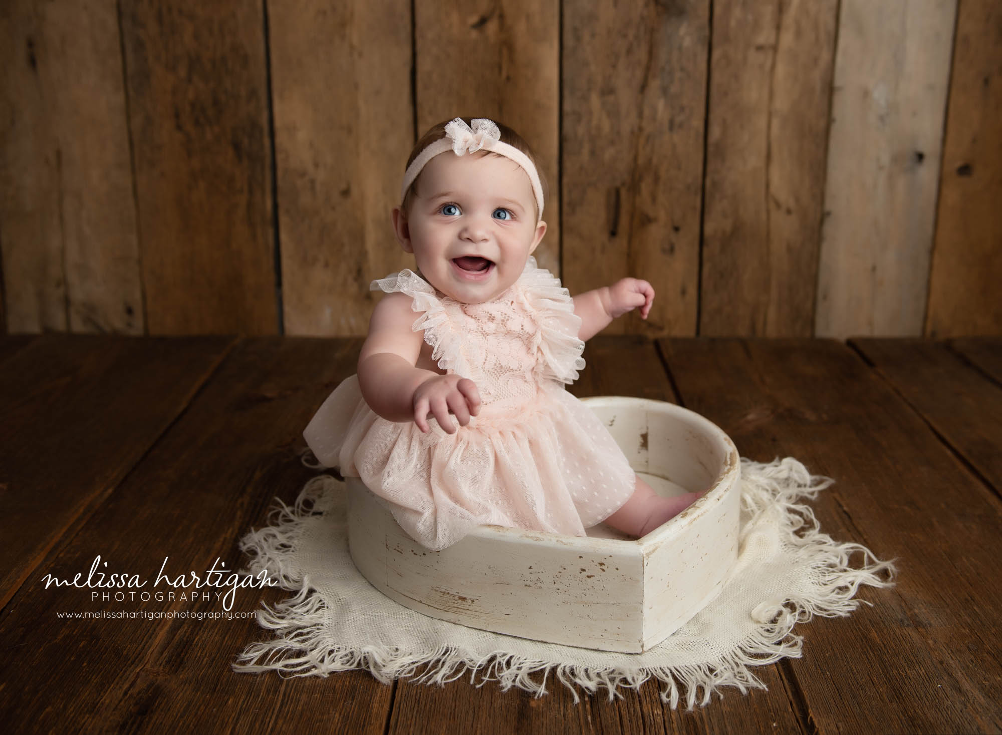 baby girl sitting in wooden heart prop smiling laughing happy CT baby photographer