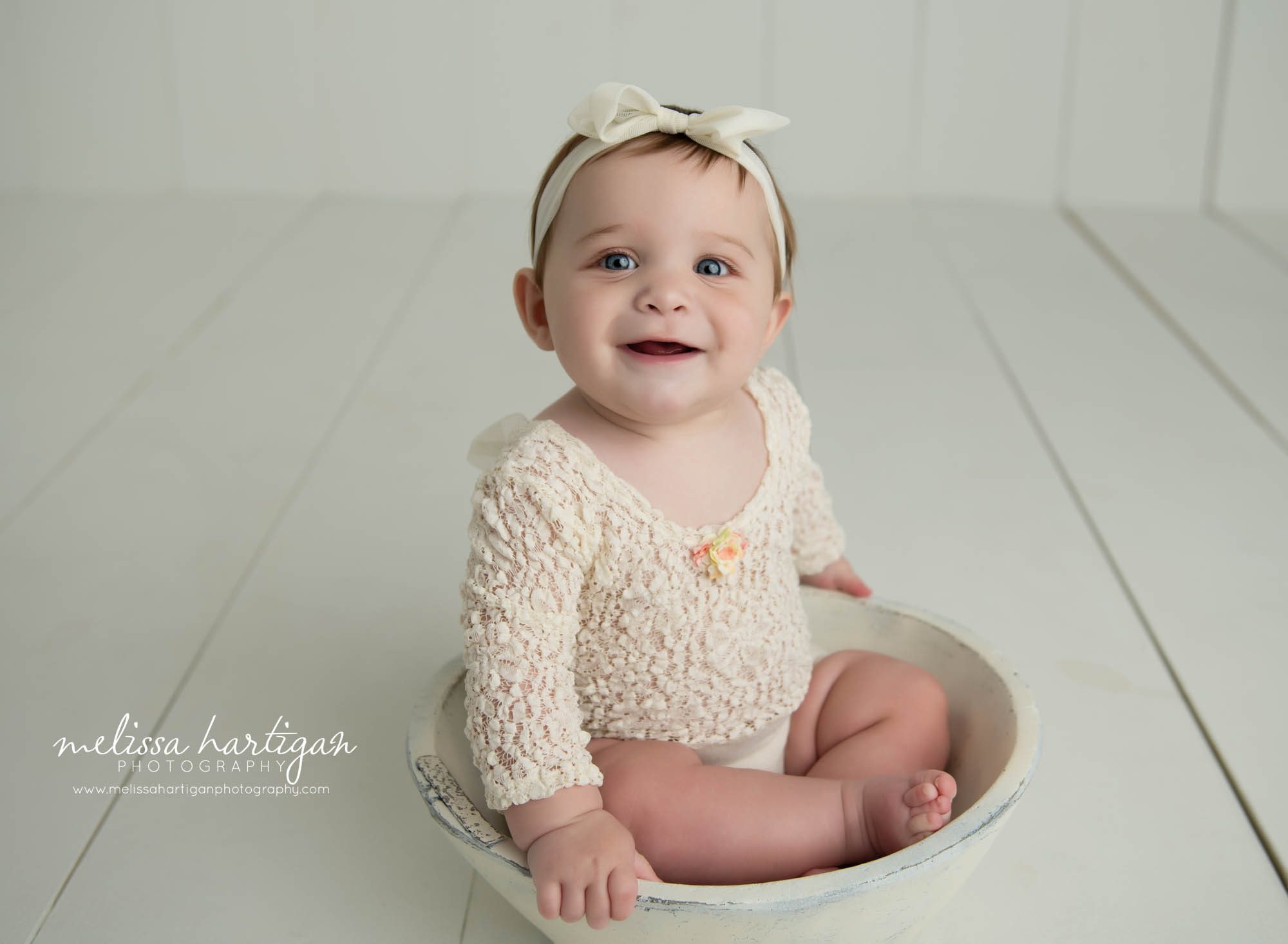 baby girl sitting in wooden bowl wearing lace outfit and bow headband CT baby photography