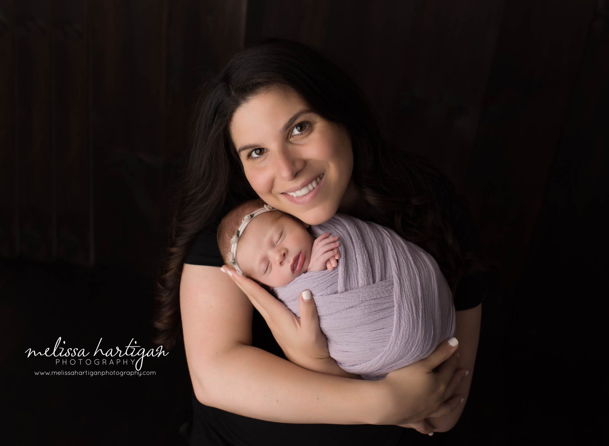 mom smiling holding newborn daughter swaddled parent pose newborn photography