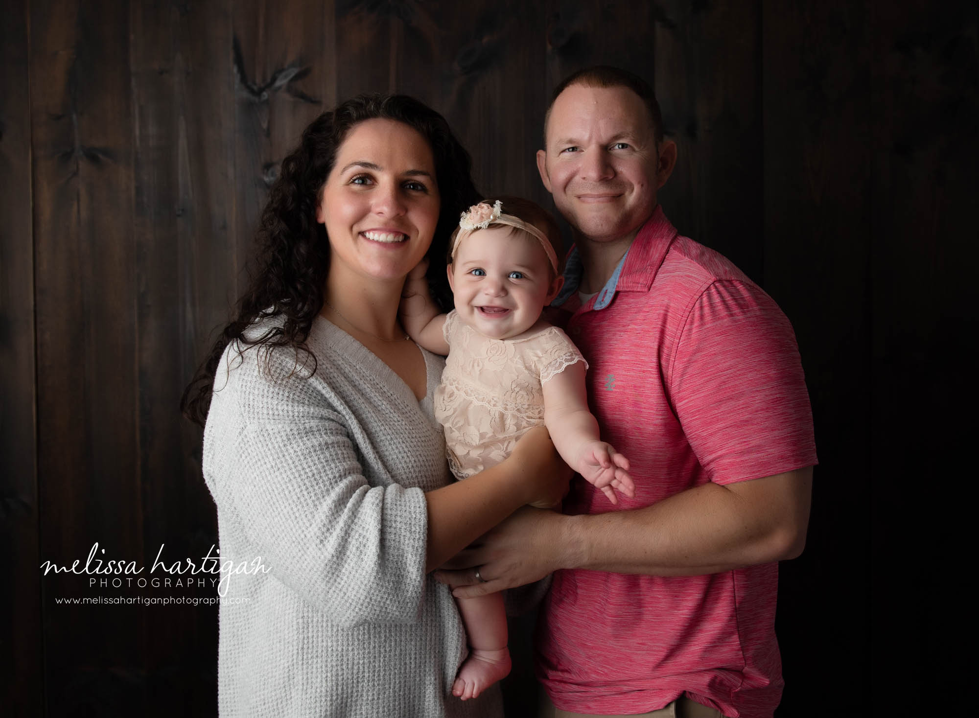 mom and dad holding baby daughter family pose Connecticut baby family photographer