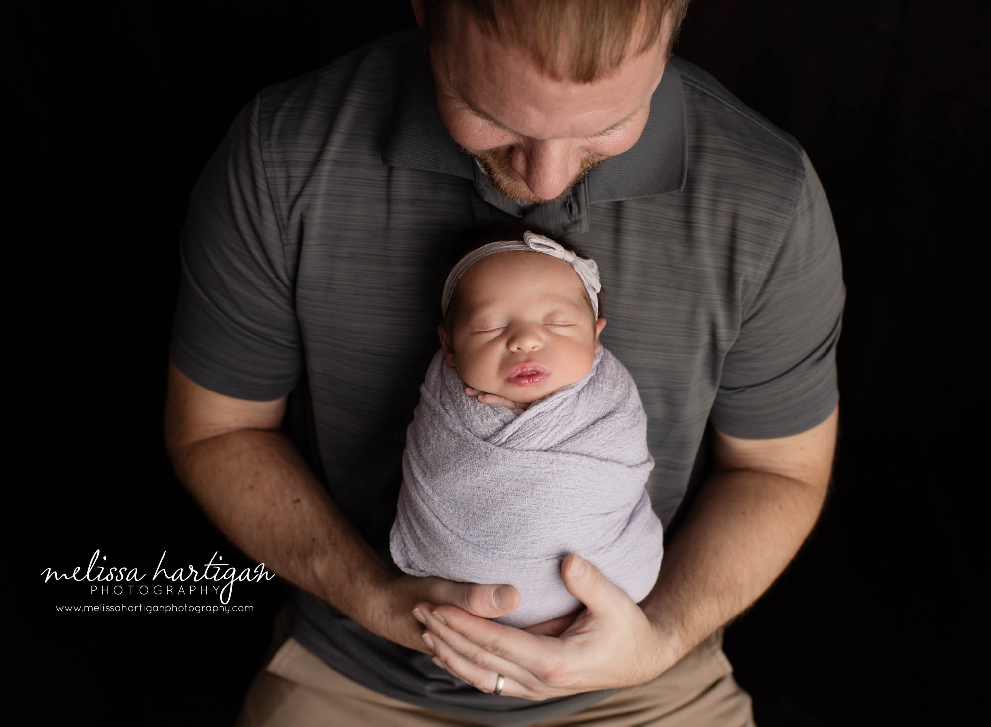dad holding newborn daughter wrapped in purple wrap CT newborn photography