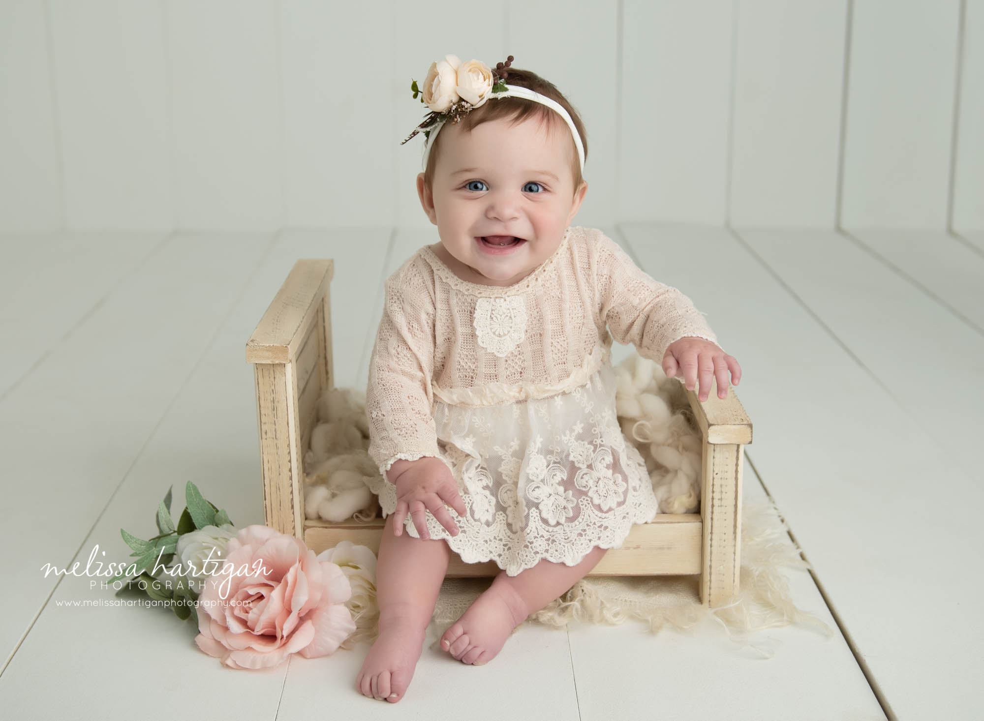 baby girl sitting on wooden bed prop smiling tolldand county baby photography