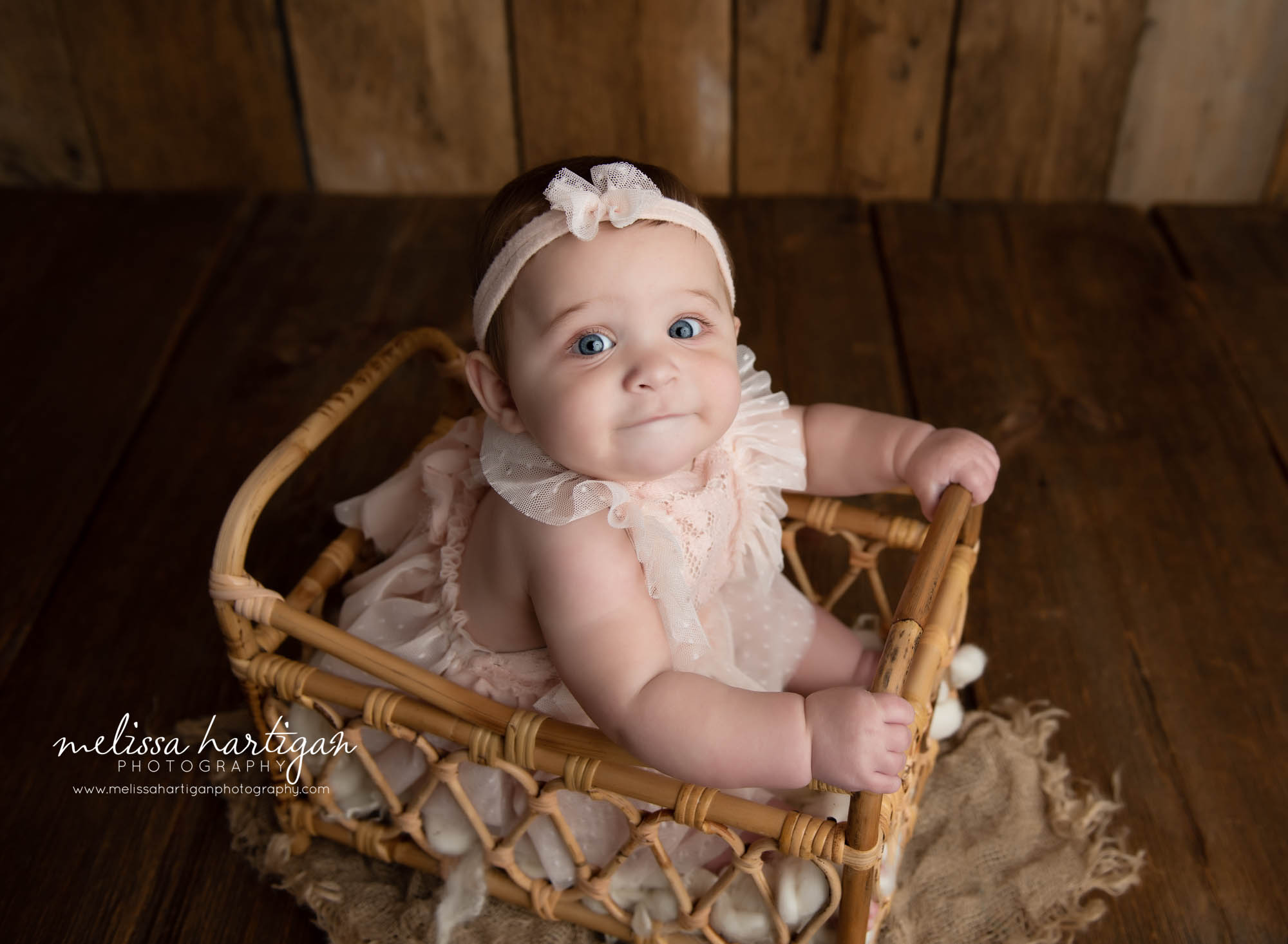 baby girl sitting in basket prop
