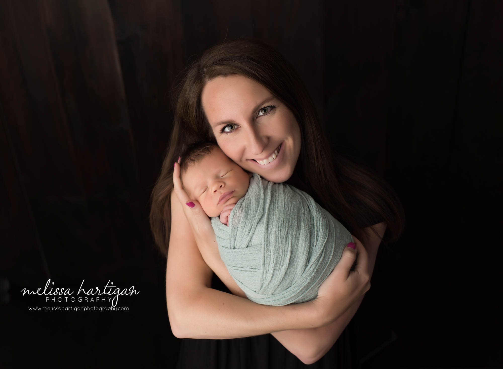 newborn baby boy swaddled in soft green posed with mom for parents pose newborn photographer CT