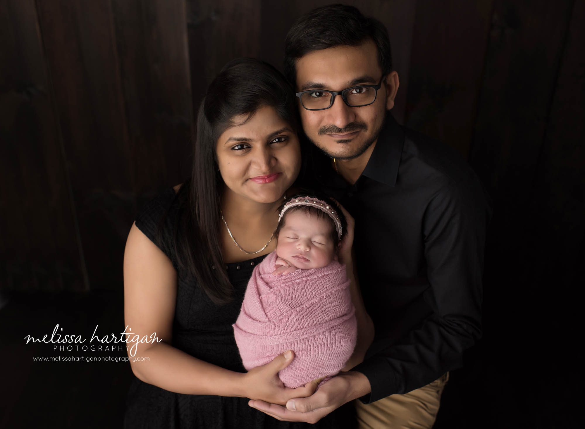 mom and dad holding newborn daughter first family picture studio newborn photography CT