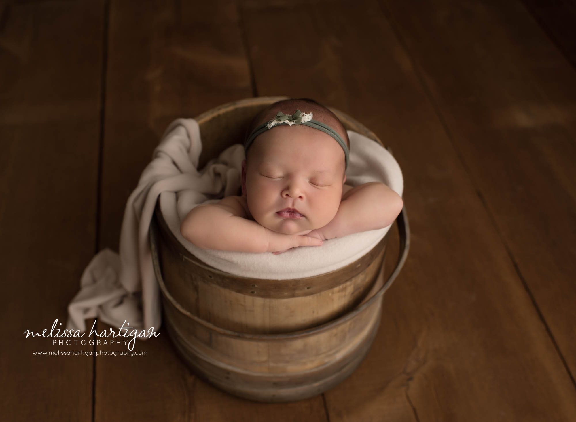 newborn baby girl posed in wooden bucket wearing headband CT newborn photographer