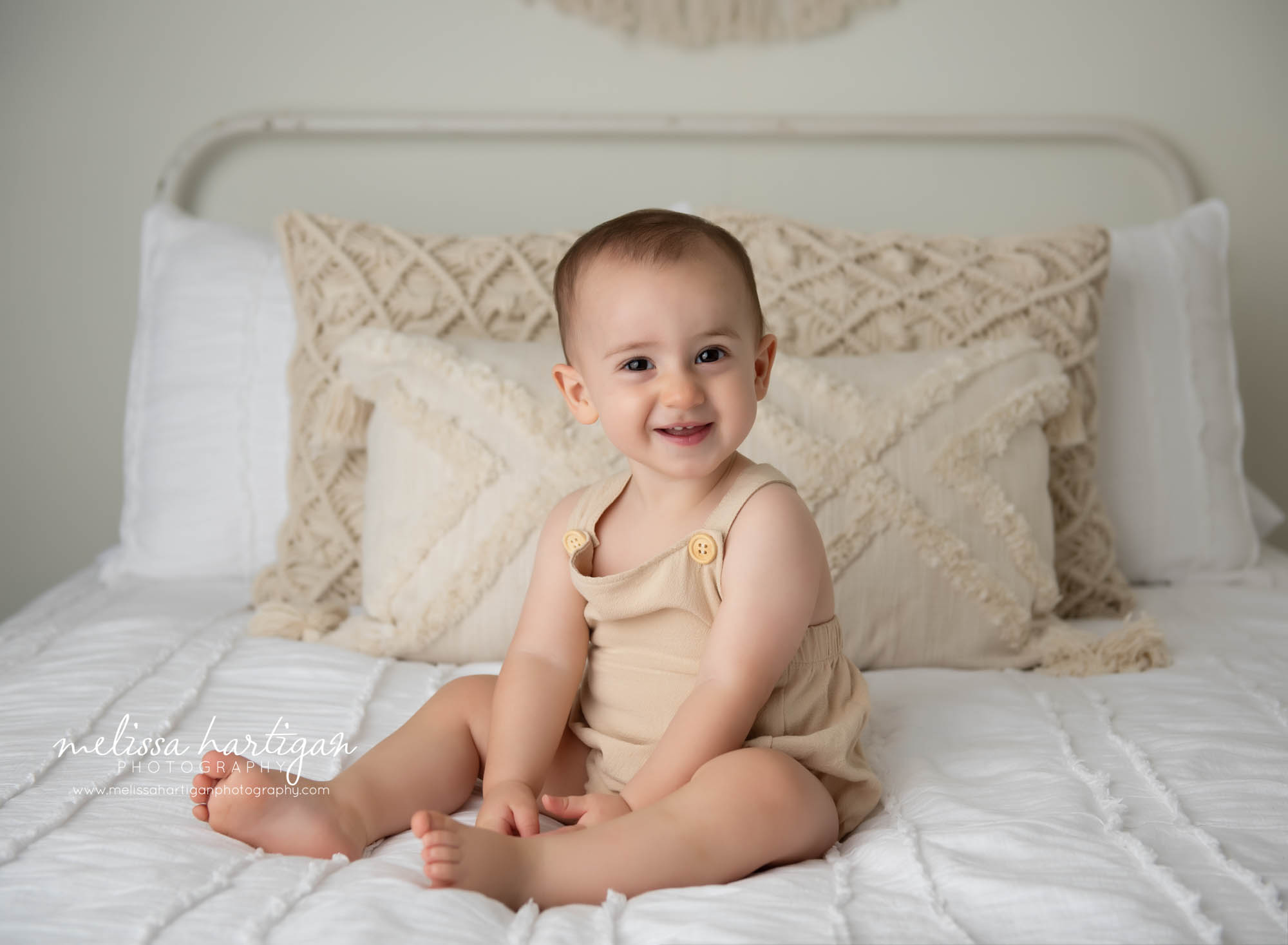 happy smiling baby boy sitting on bed wearing baby outfit stafford springs baby photorgaphy