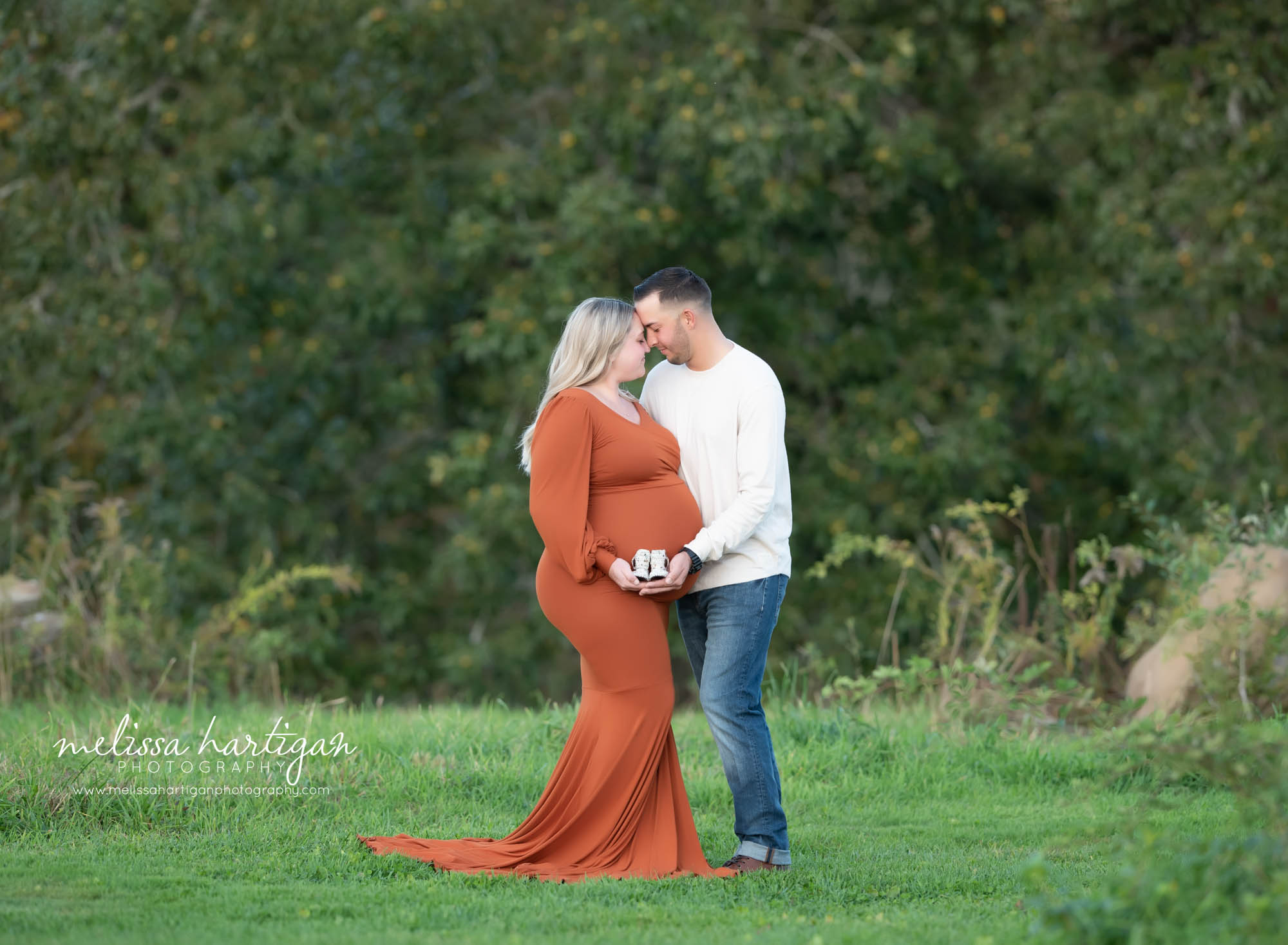 couple standing together holding baby shoes close to baby bump maternity newborn photography CT