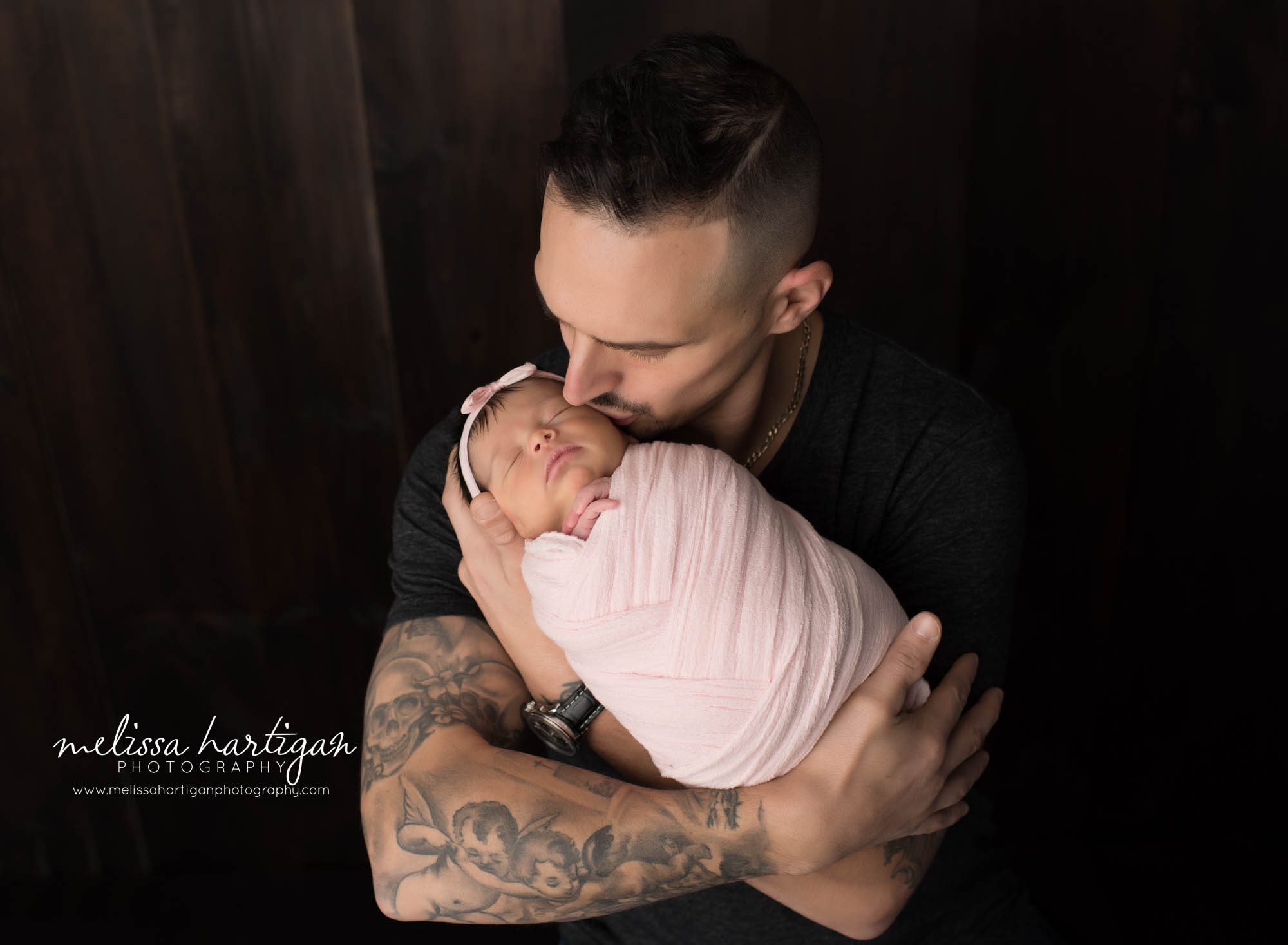 dad holding newborn daughter in parents pose newborn photography CT east hartford session